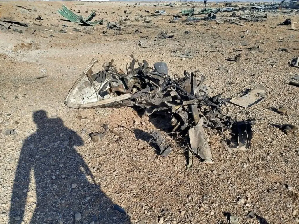 Wreckage of a US aircraft scattered across a desert landscape.