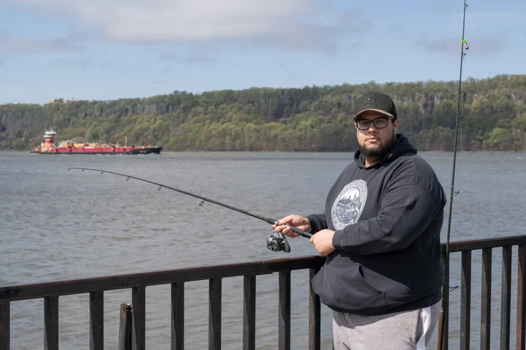 Gilbert Diaz fishing for stripped bass from the Dyckman Pier.