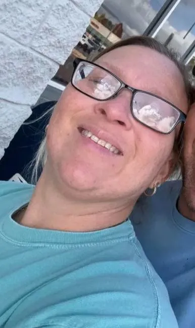 Lisa Gail Fields, 46, smiling in a light blue shirt and glasses.