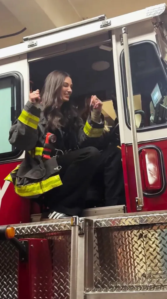 Dana Treacy and Hailey Carlson dancing in a fire truck.
