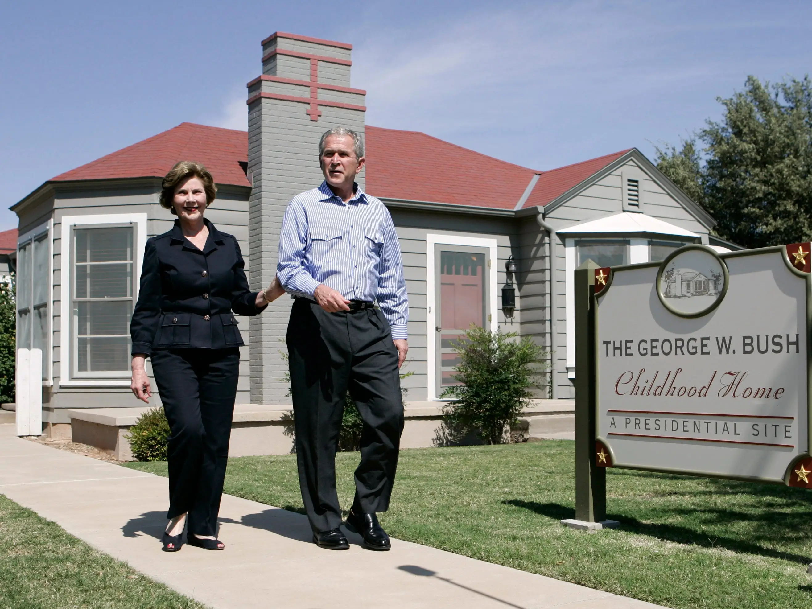Then-President George W. Bush and first lady Laura Bush visited his childhood home in Midland, Texas. A large sign denotes, 