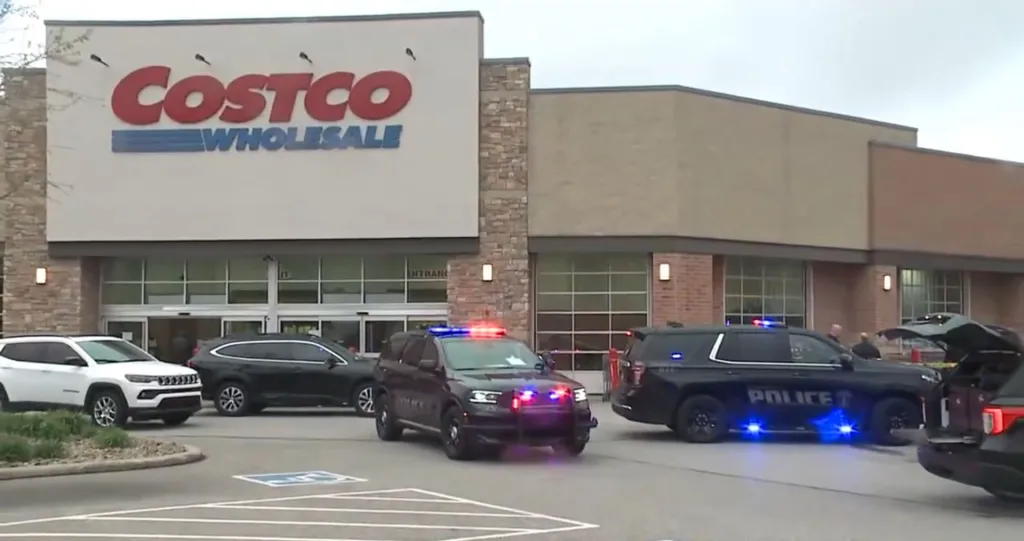 Police vehicles with flashing lights outside a Costco store.