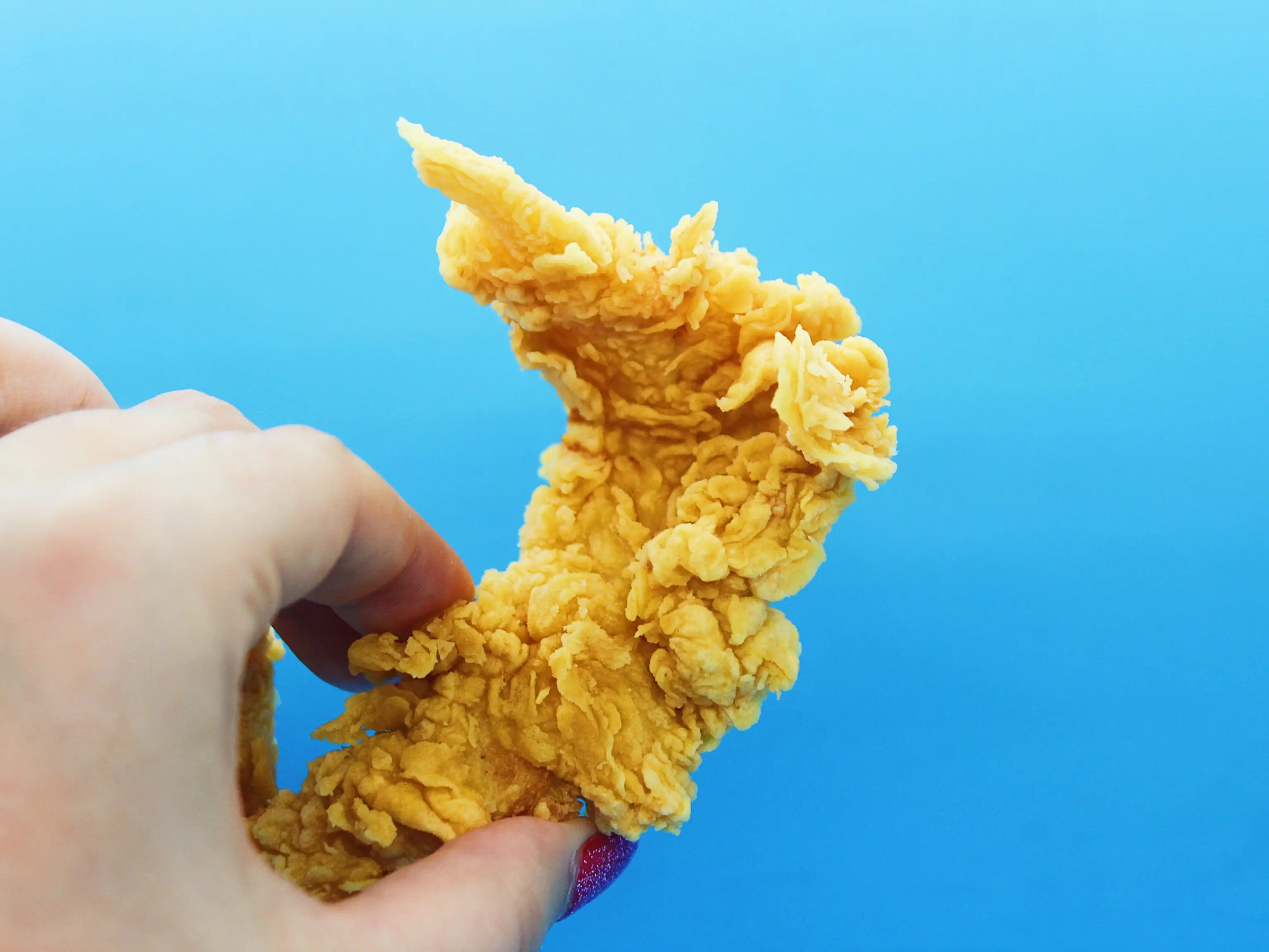 popeyes chicken tender on blue background