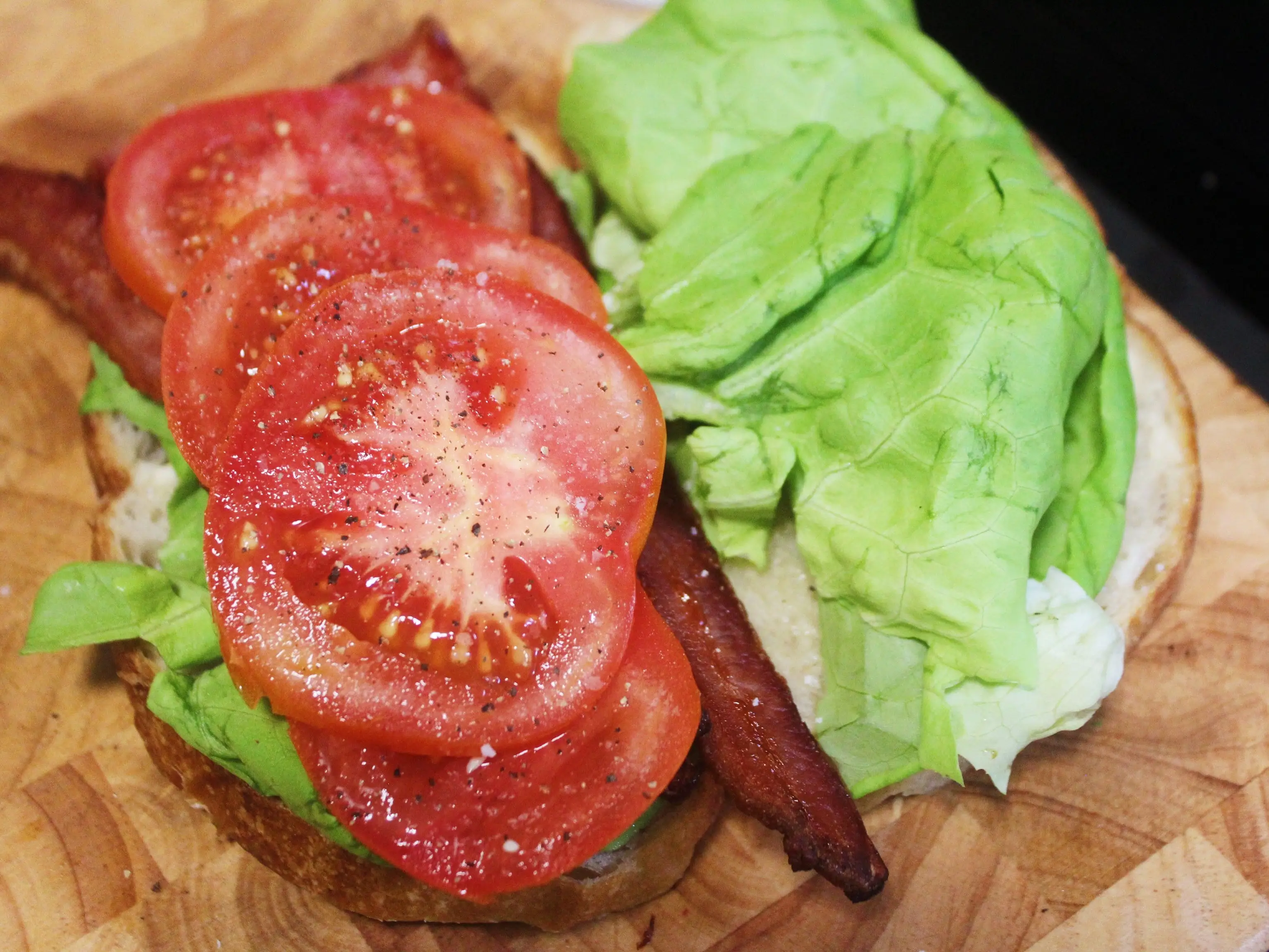 lettuce tomato avocado and bacon on two slices of bread