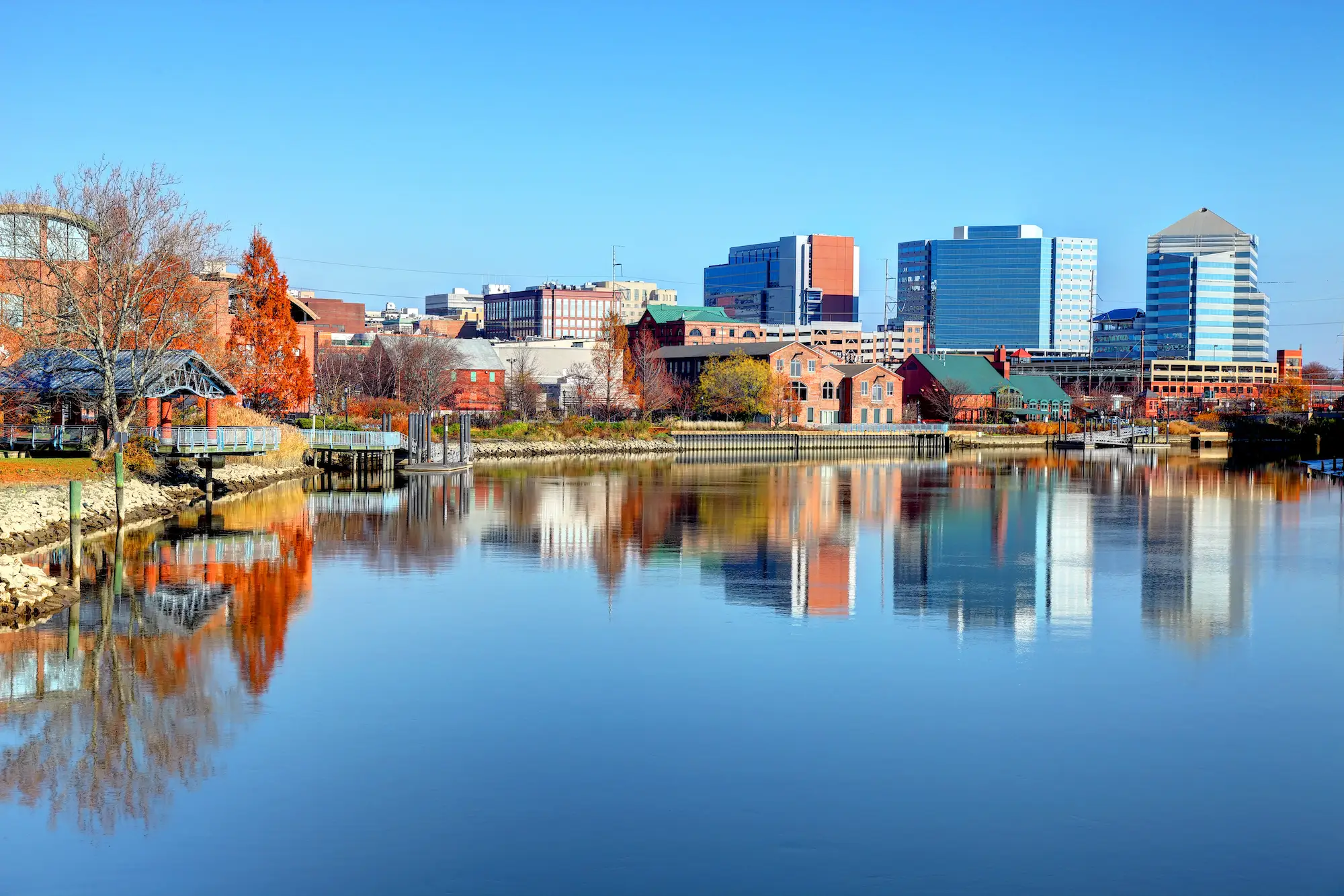 Buildings and trees reflected on water.