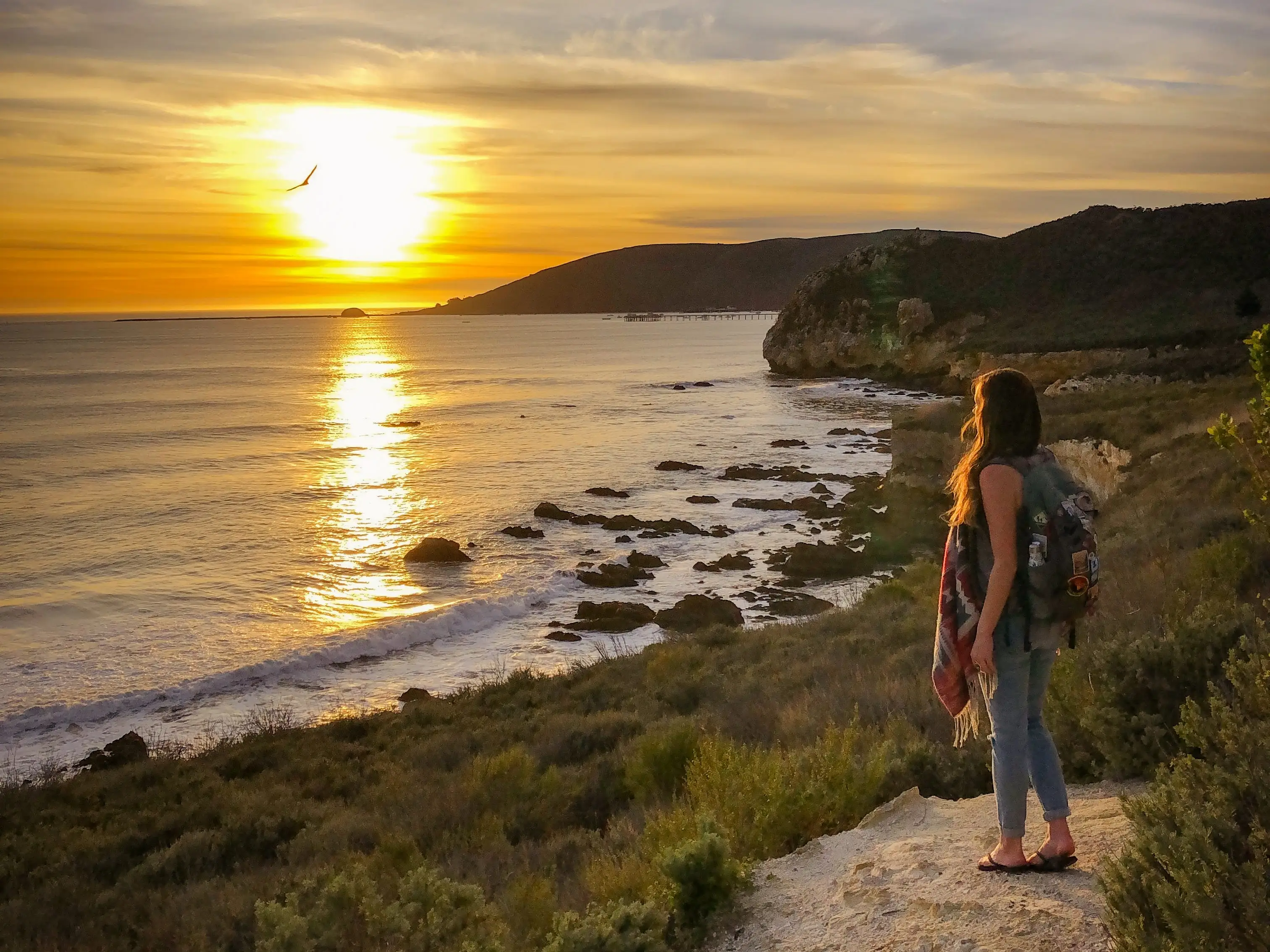 Emily looks out at the sunset on a California beach.