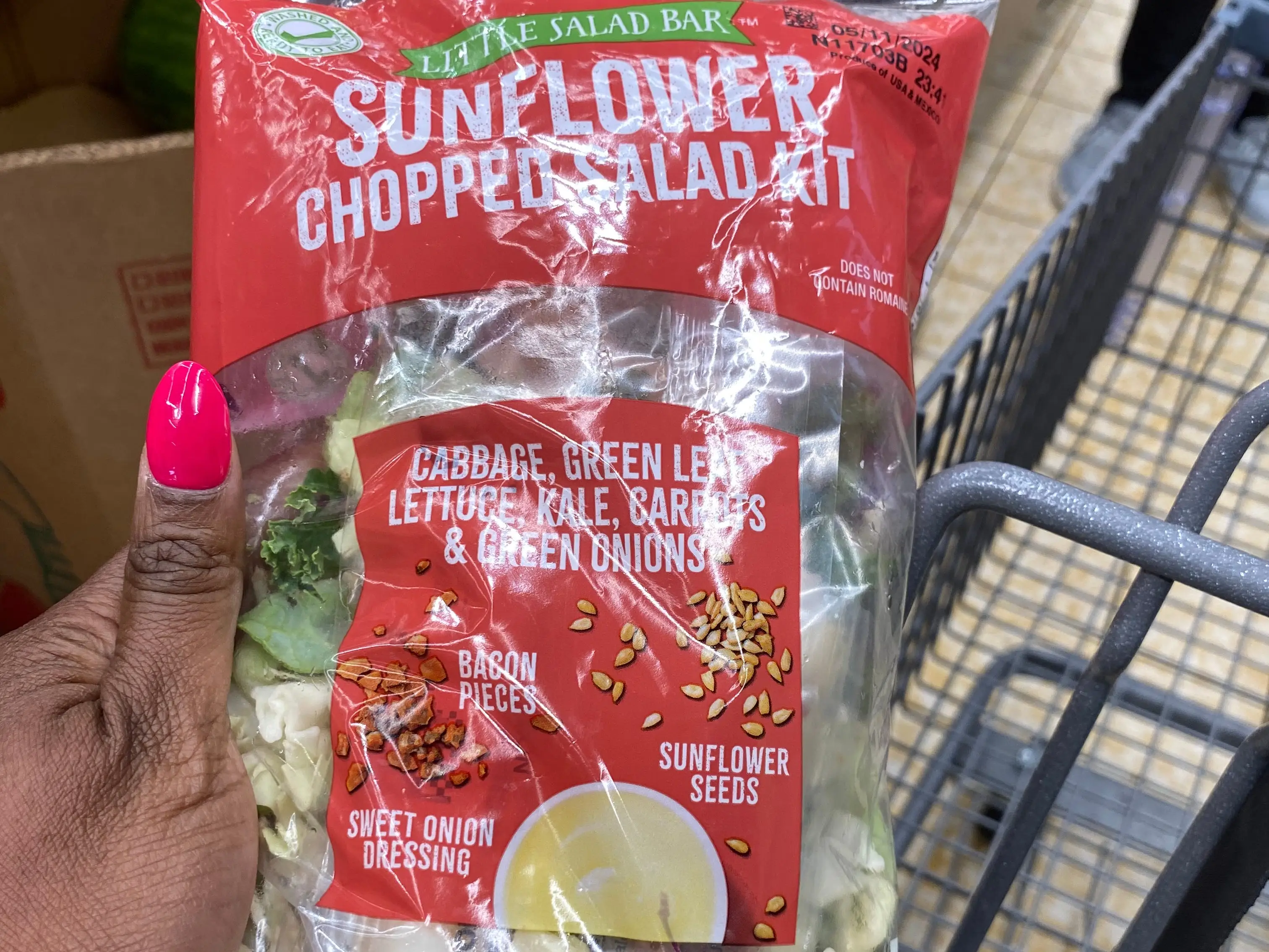 hand holding up a bagged salad kit at aldi
