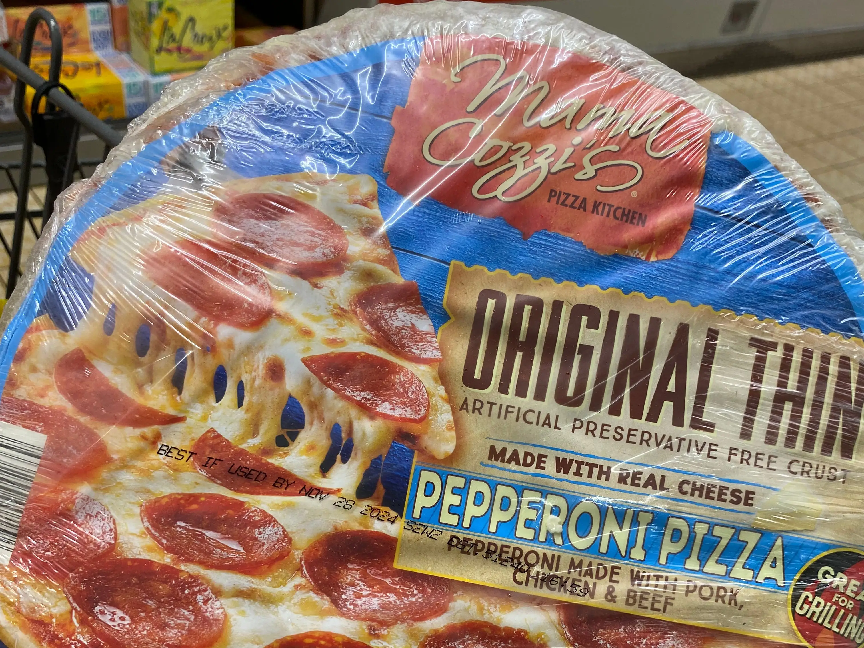 hand holding up a pepperoni pizza at aldi
