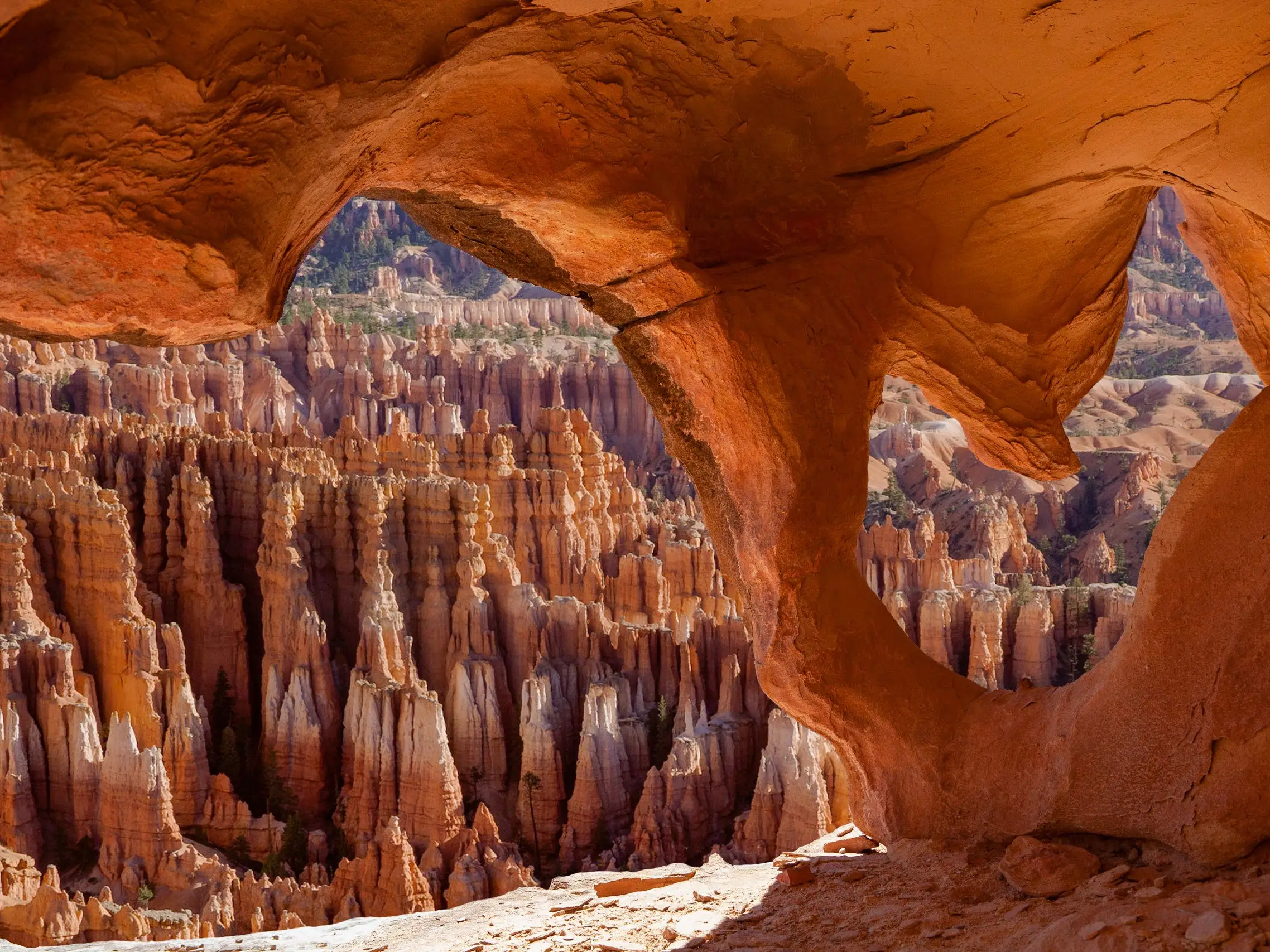 Red rock formations seen from inside a curved cave