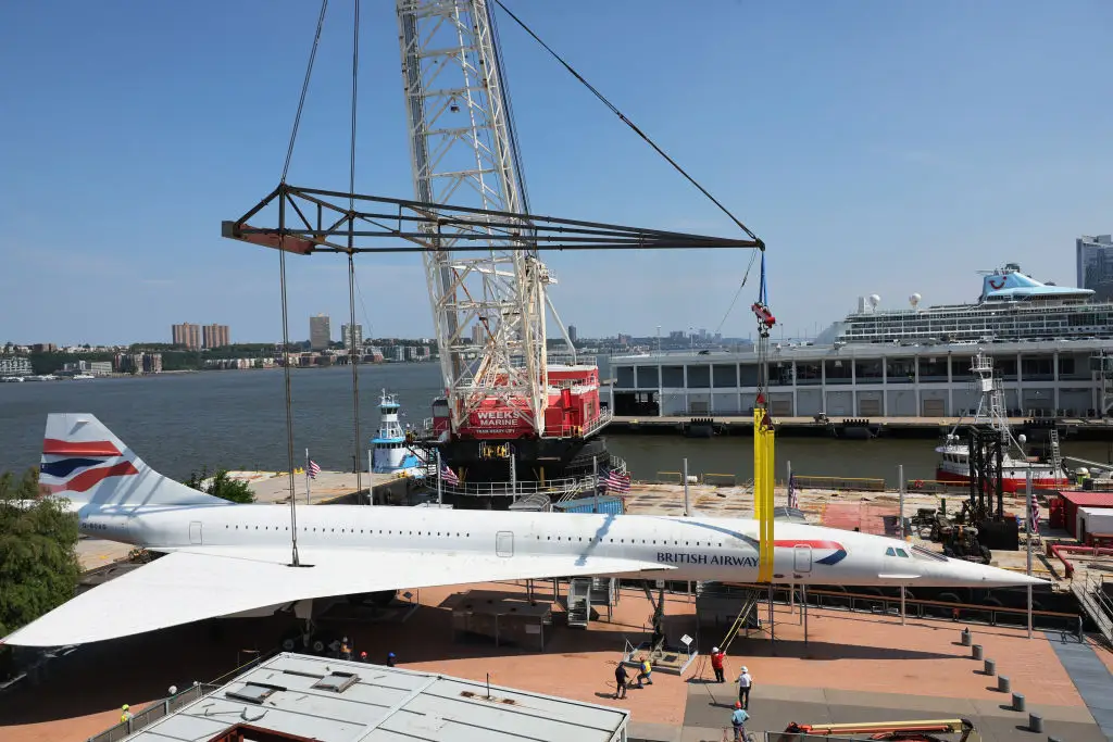 A Concorde plane being lifted by a crane at the Intrepid Museum.
