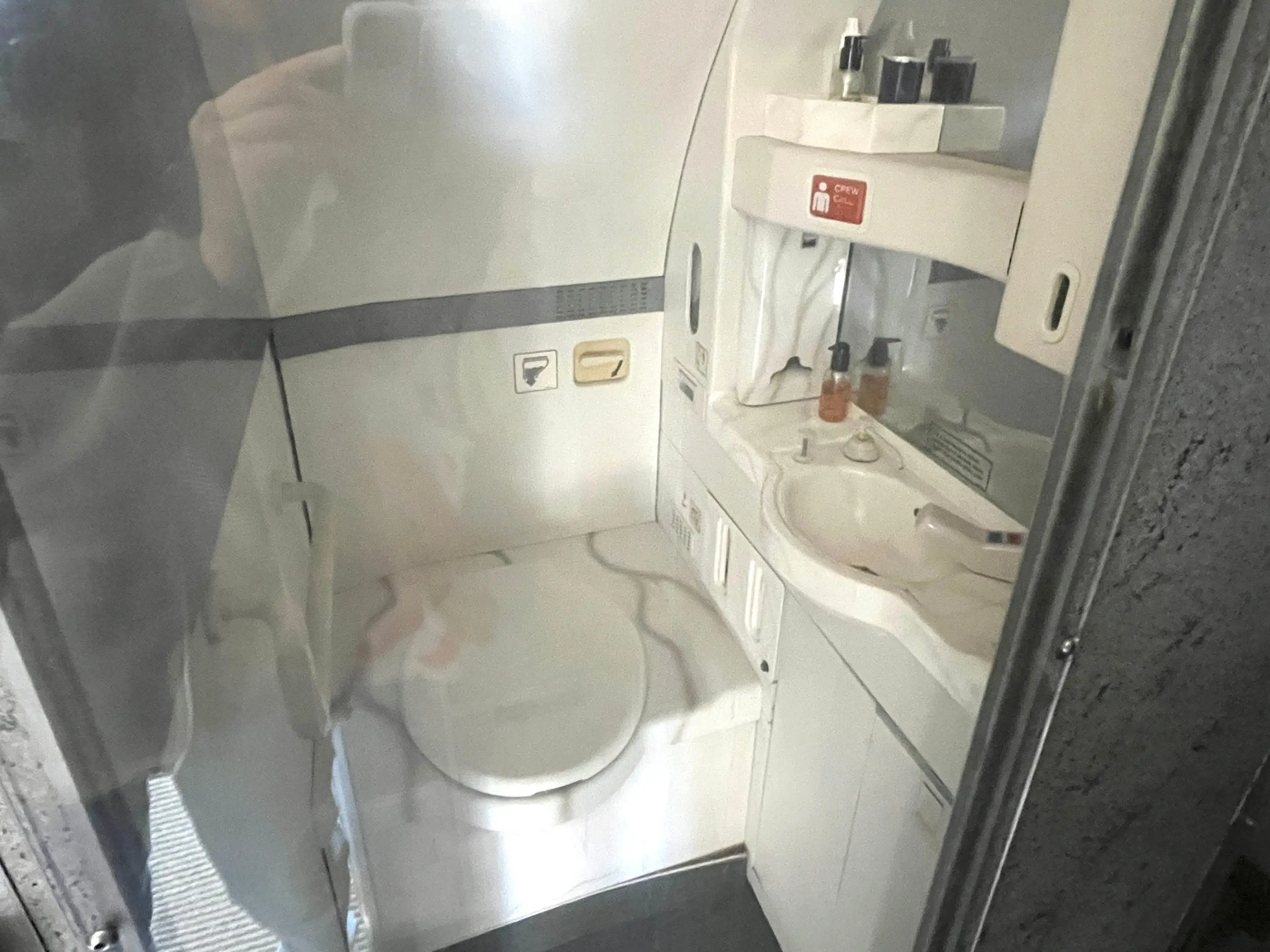 A plane bathroom behind glass.
