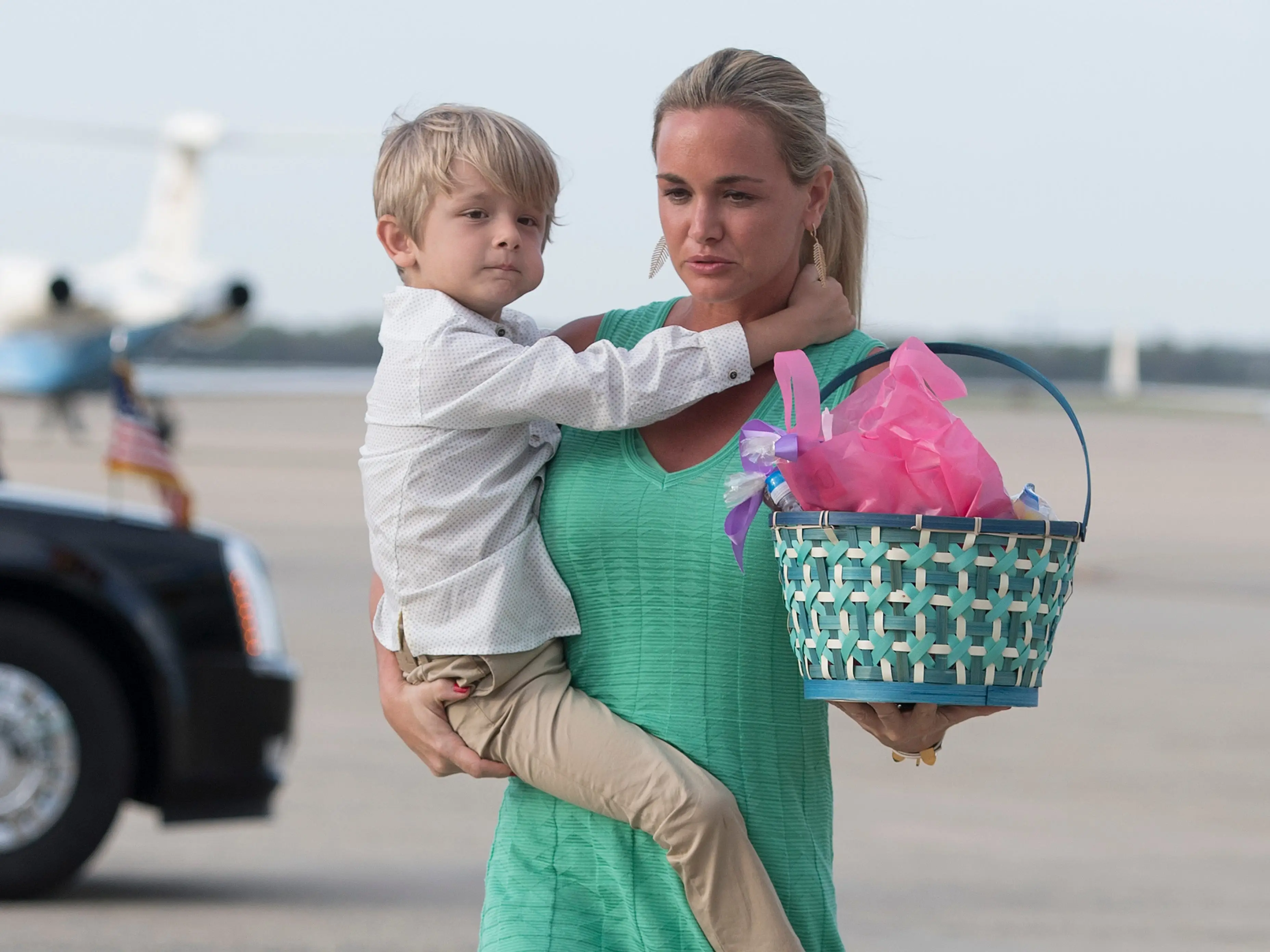 Vanessa Trump holding her son Tristan Trump on her hip and carrying a woven baset.