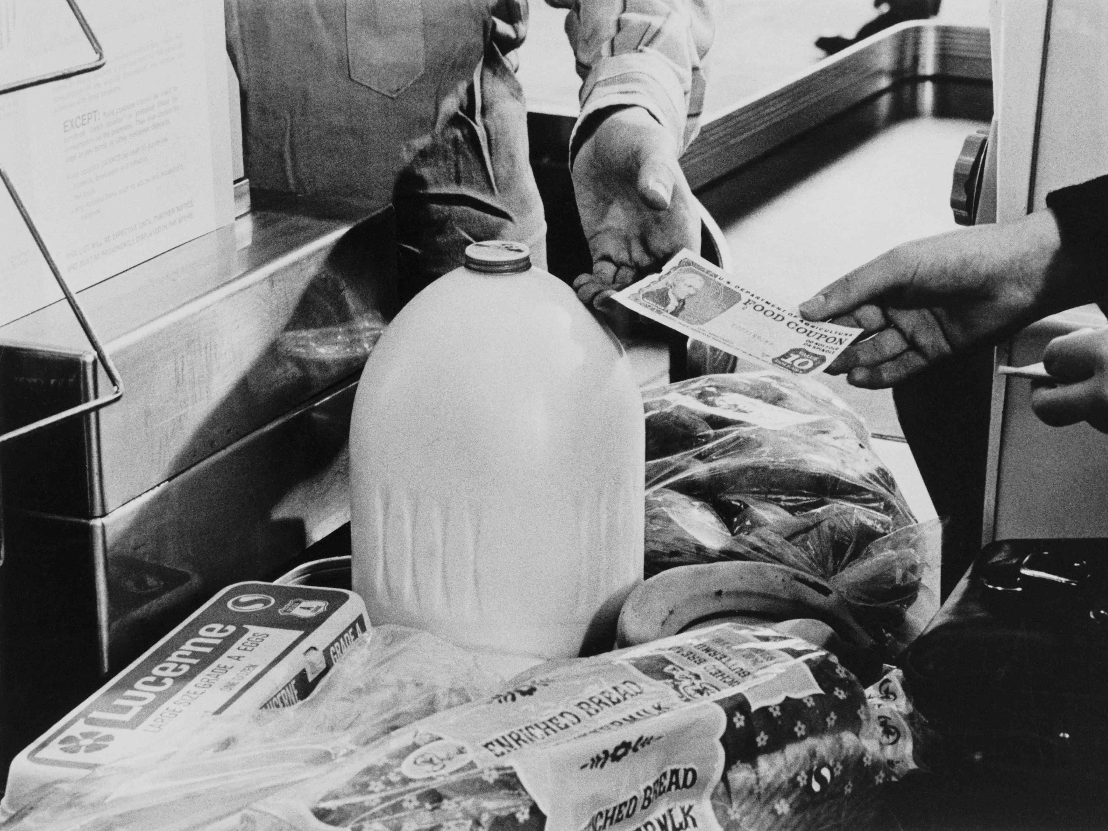 A person in Washington D.C. paying for groceries with food stamps in 1975.
