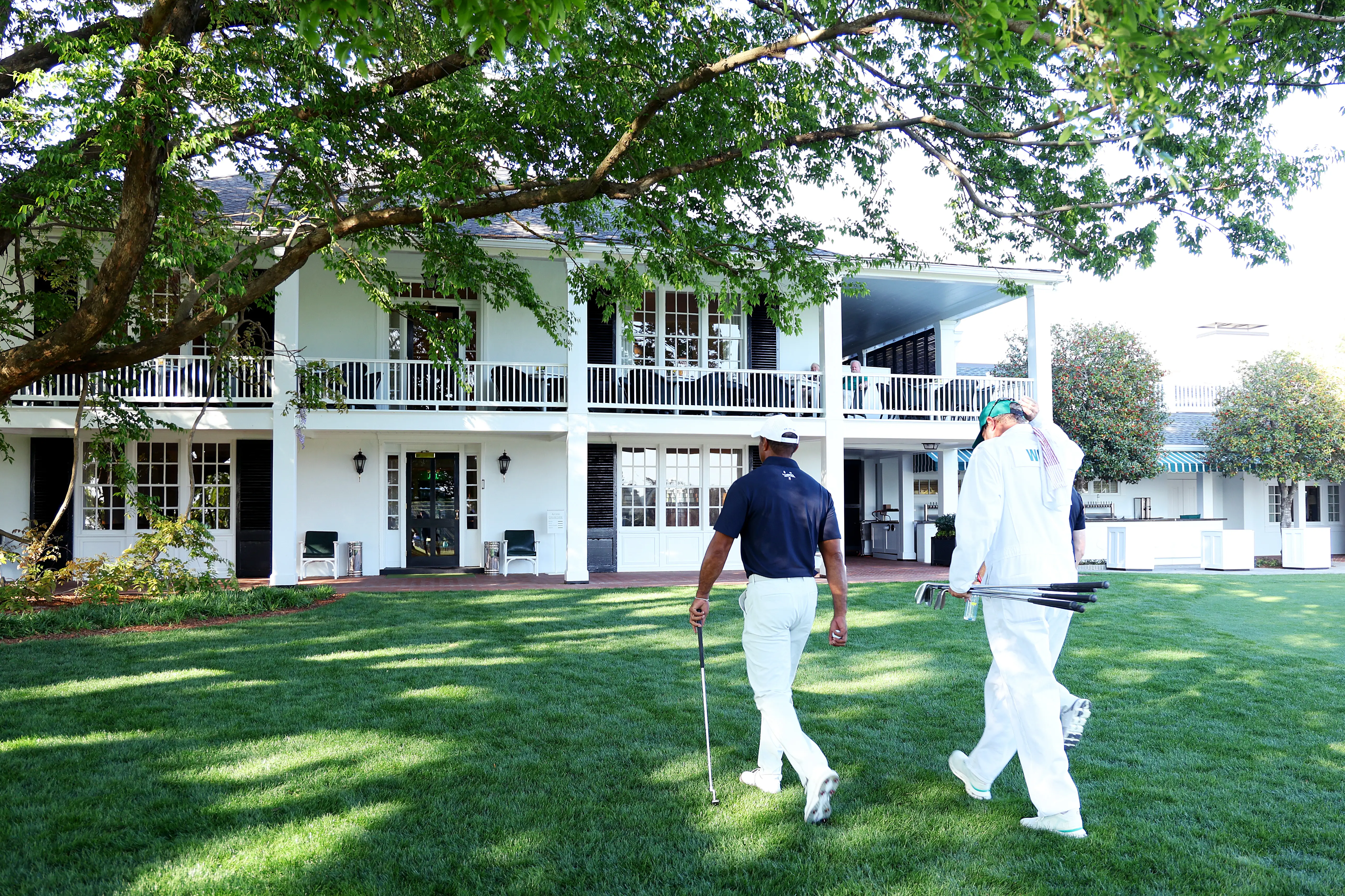Tiger Woods leaves the course to enter the Clubhouse after practicing a few holes with Rob McNamara and caddie Lance Bennett prior to the 2024 Masters Tournament at Augusta National Golf Club.