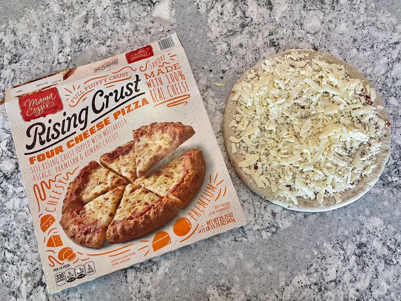 Moma Cozzi's rising crust four cheese pizza box next to frozen pizza topped with cheese