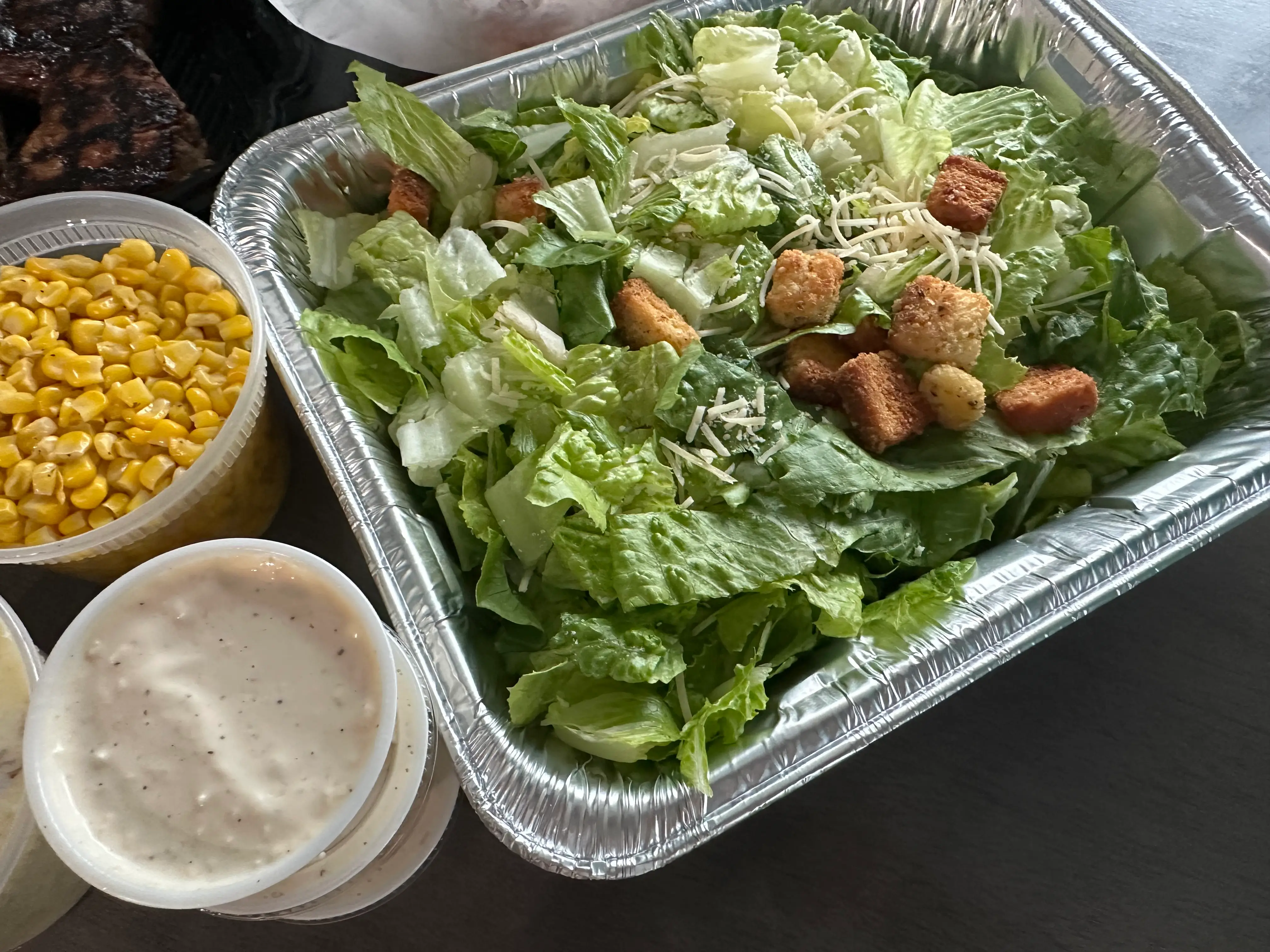 Salad with croutons, container of dressing on side