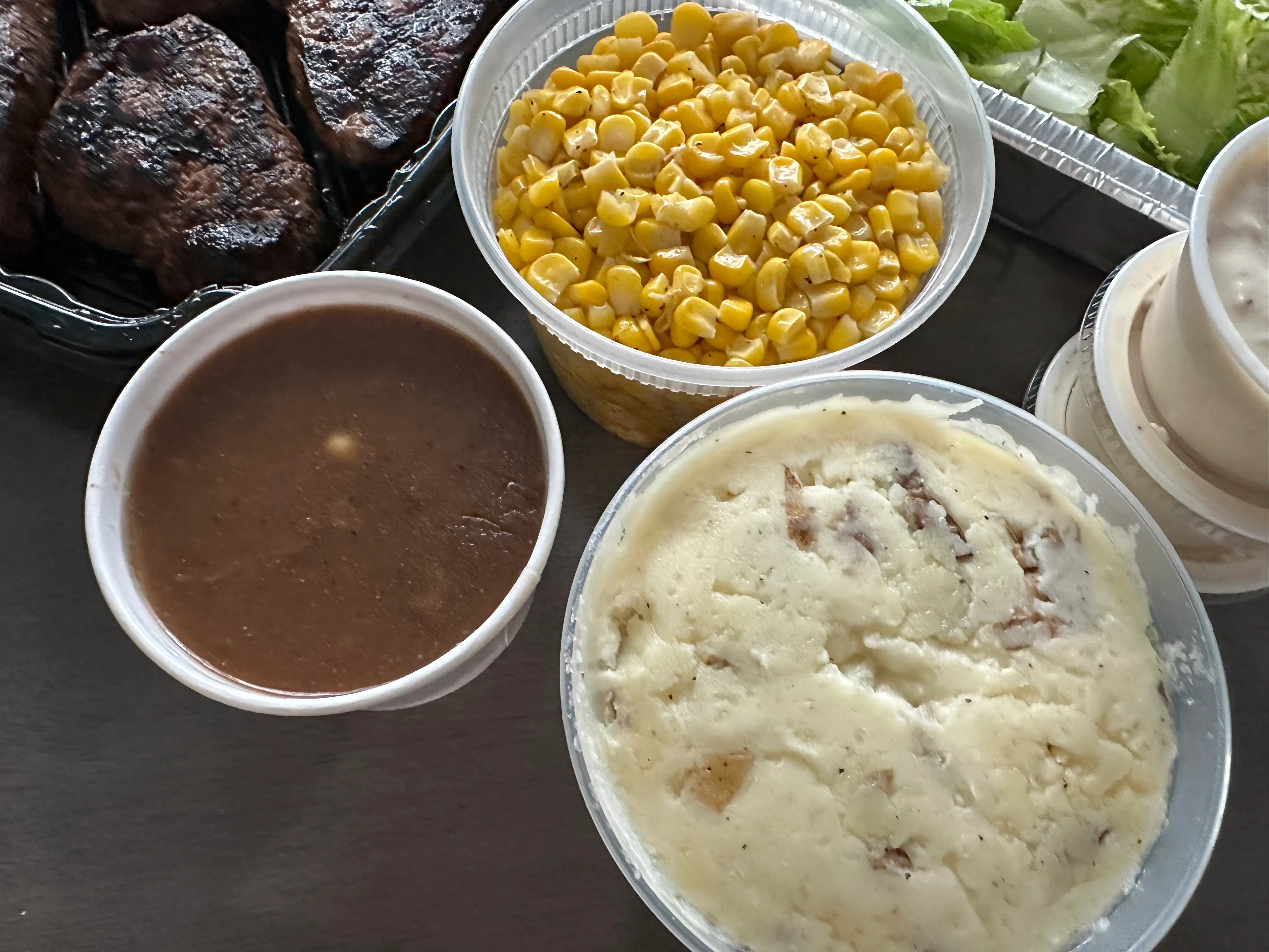 Mashed potatoes, gravy, corn in containers