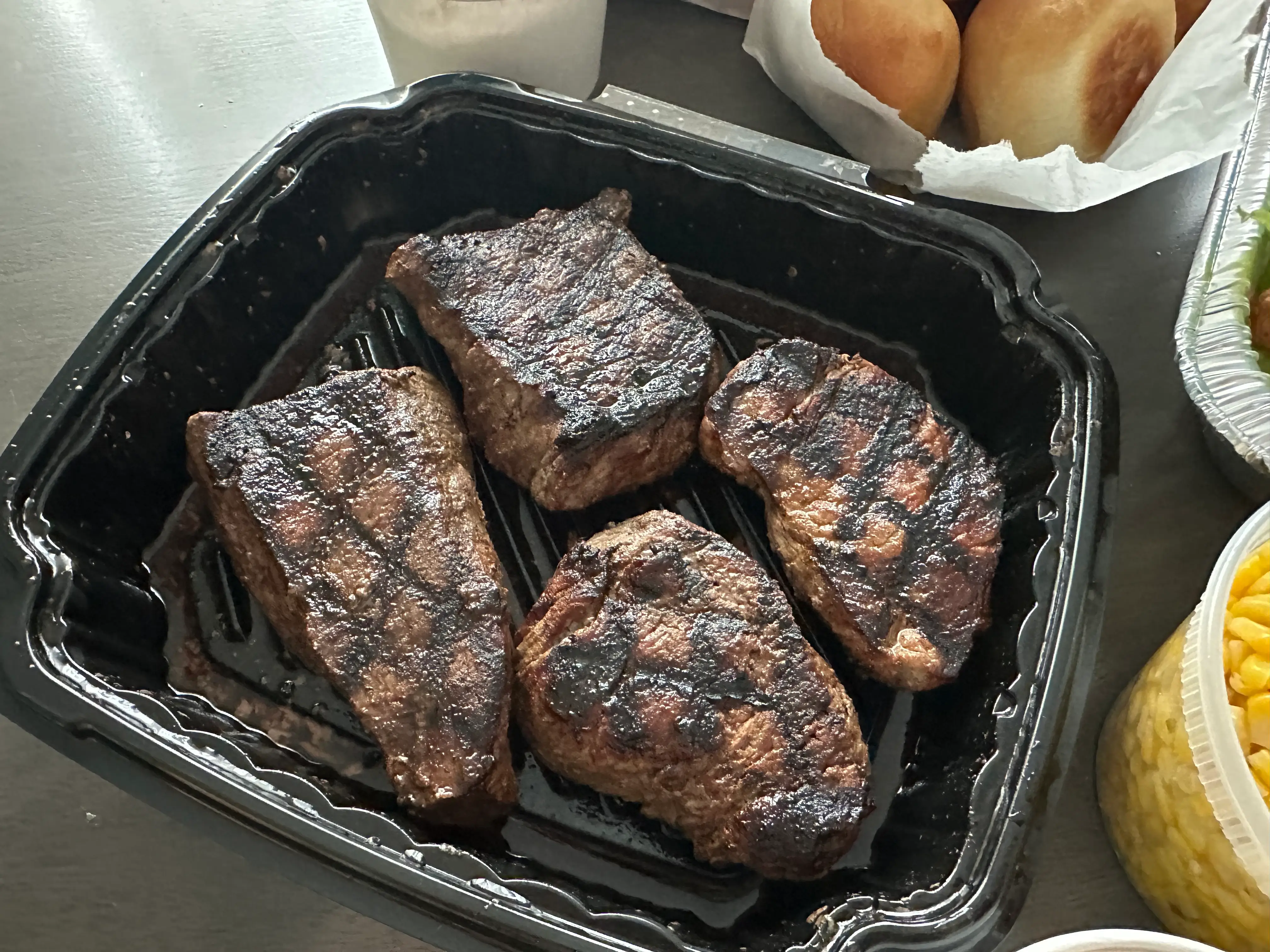 Four steaks in container