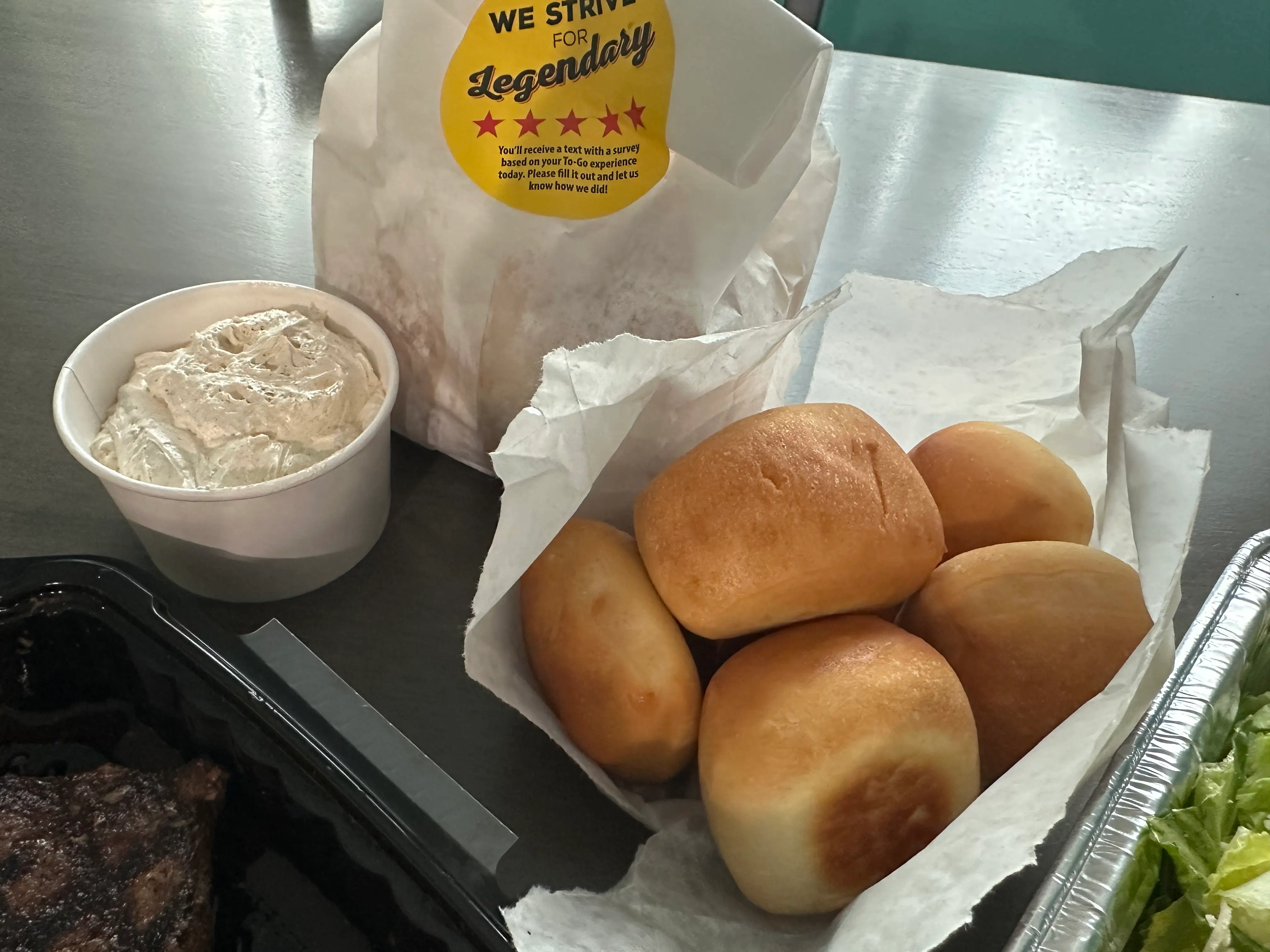 Texas Roadhouse rolls with container of cinnamon butter