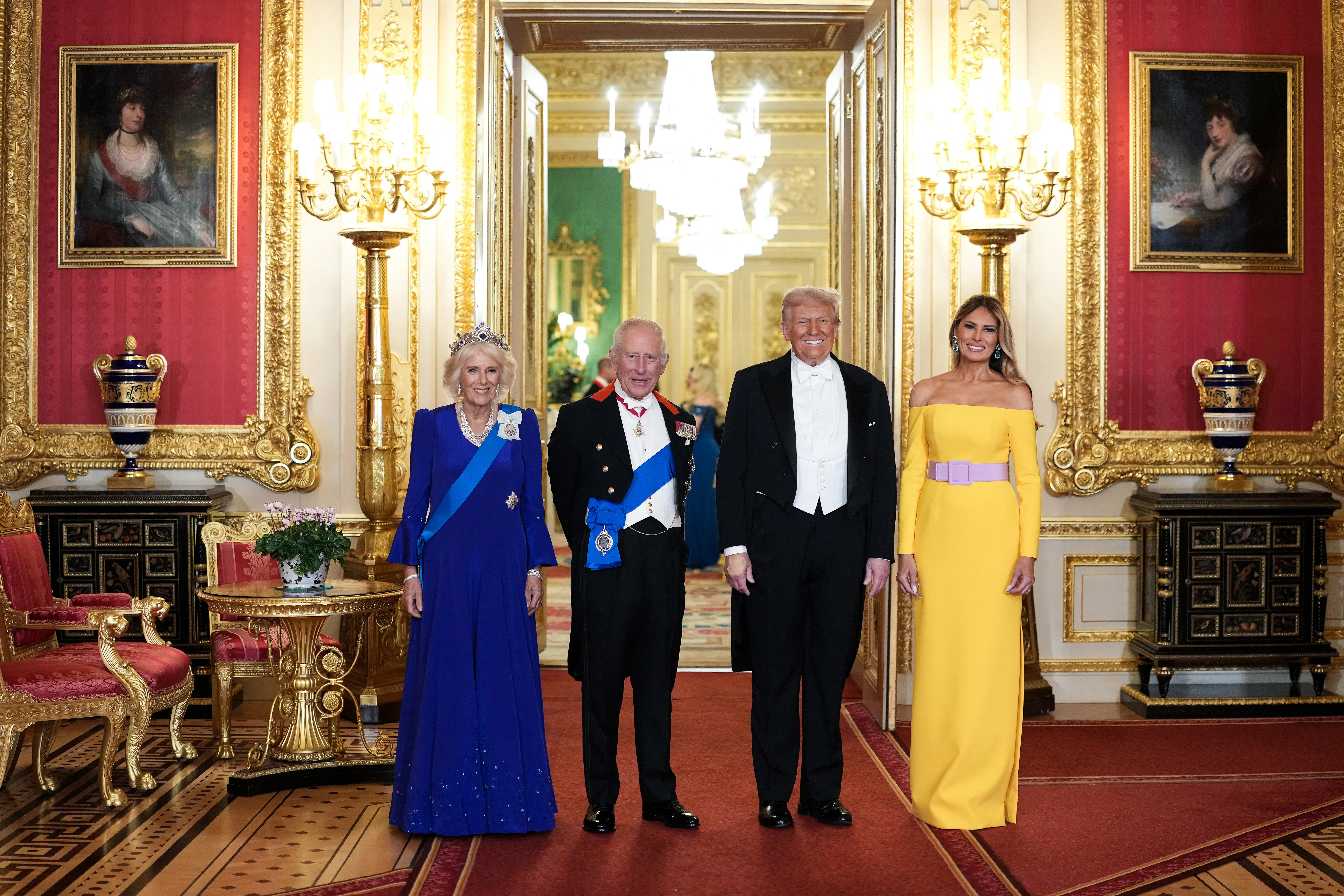 Queen Camilla, King Charles, Donald Trump, and Melania Trump standing side-by-side in an ornately decorated room.