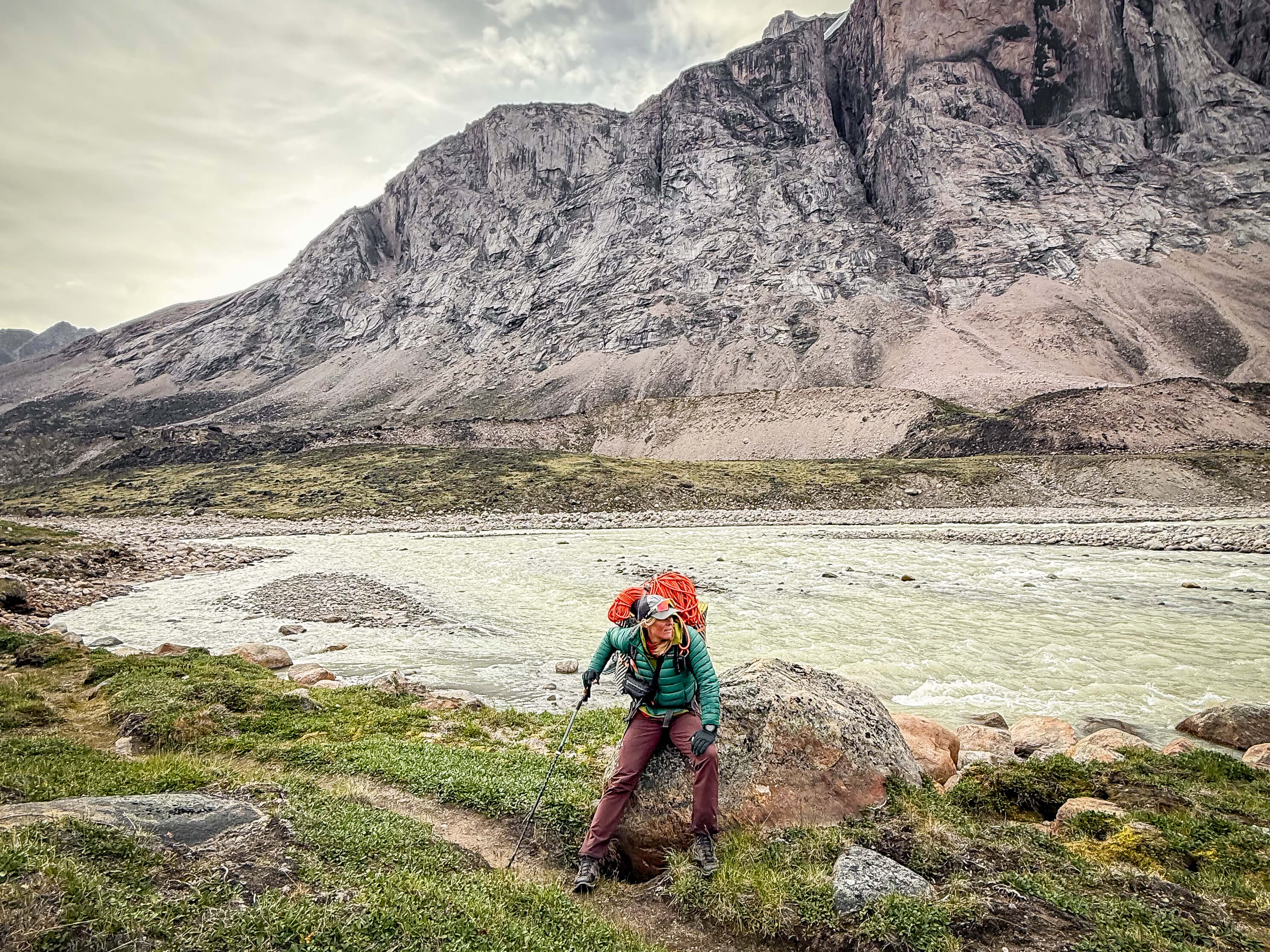 Sunny Stroeer sitting on a rock in the mountains.