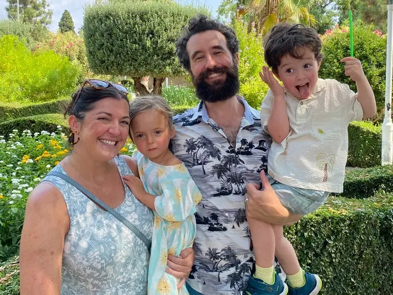 Family smiling in front of t