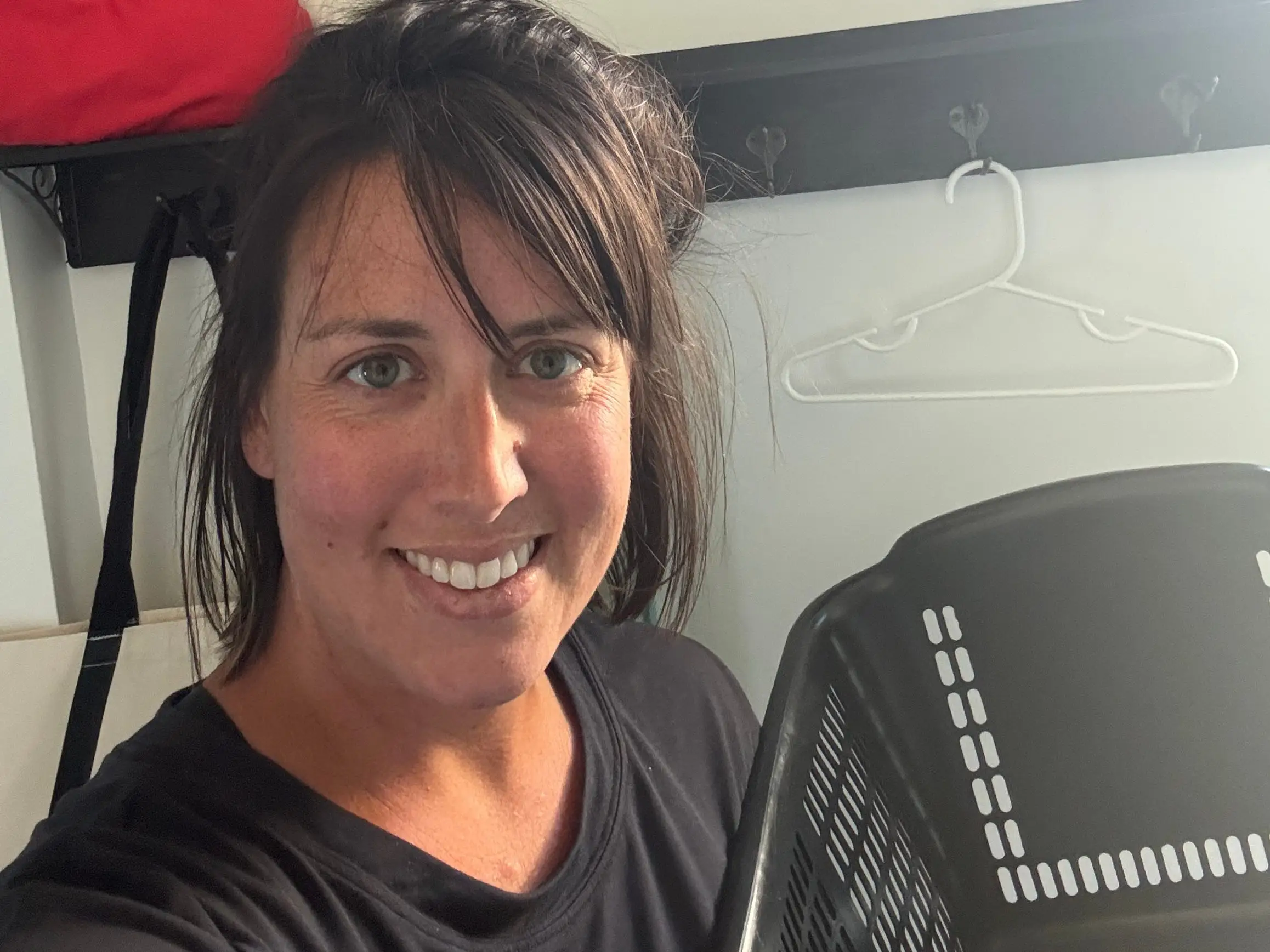 Author smiling with Frostys Laundry sign in house