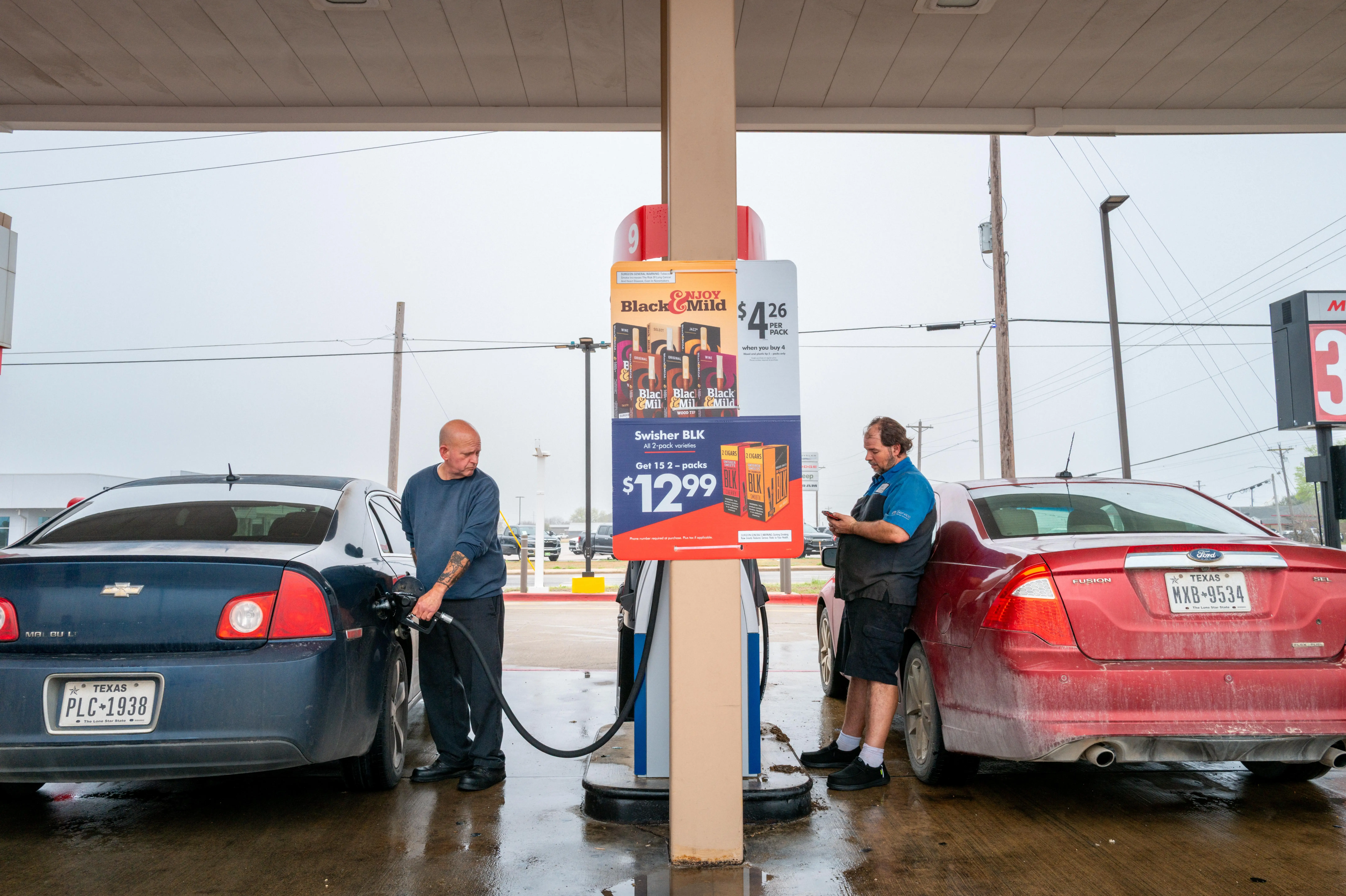Two men pumping gas