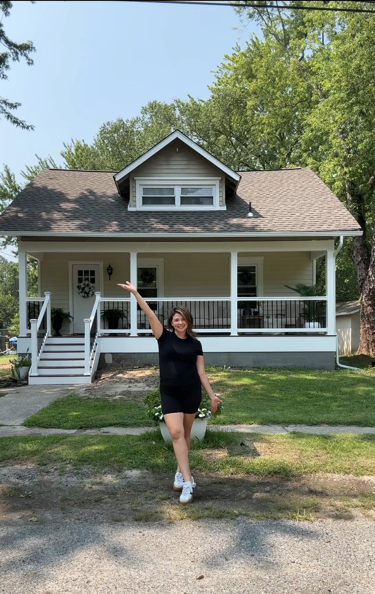 A woman standing in front of a newly renovated home.