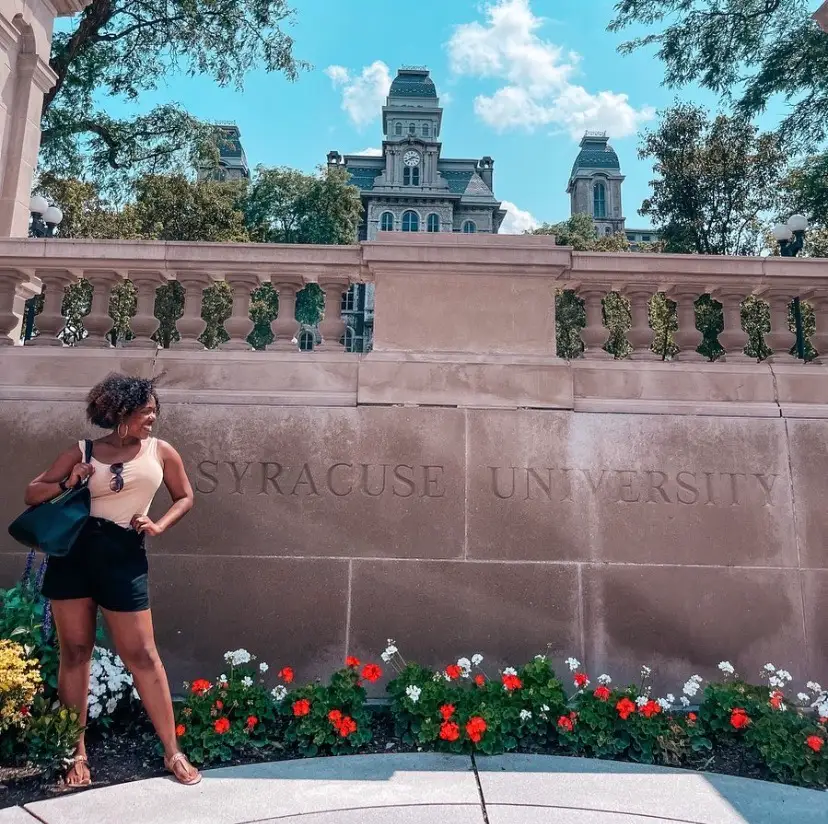 Woman posing at Syracuse university sign