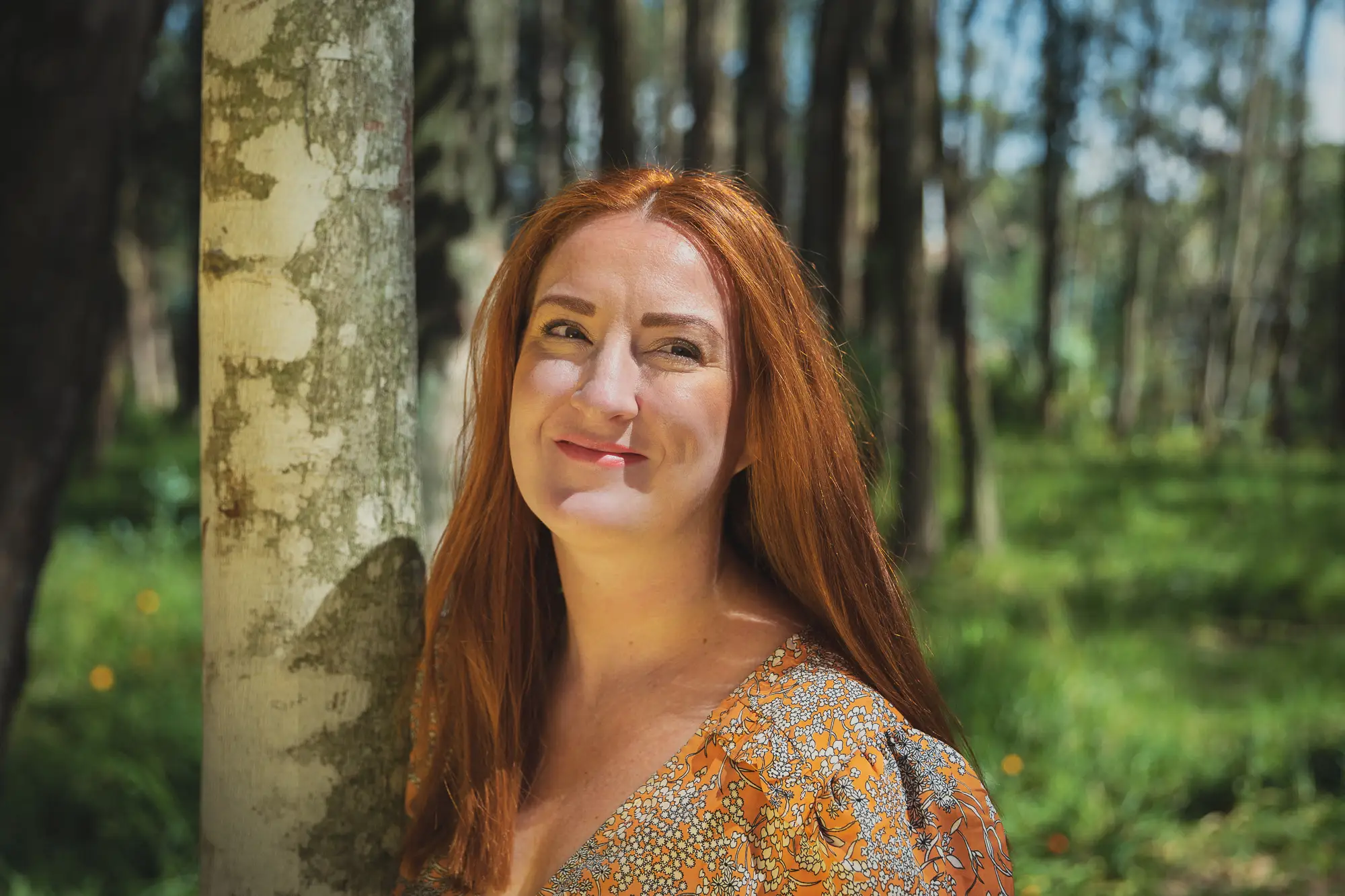 A woman posing next to a tree in South America.