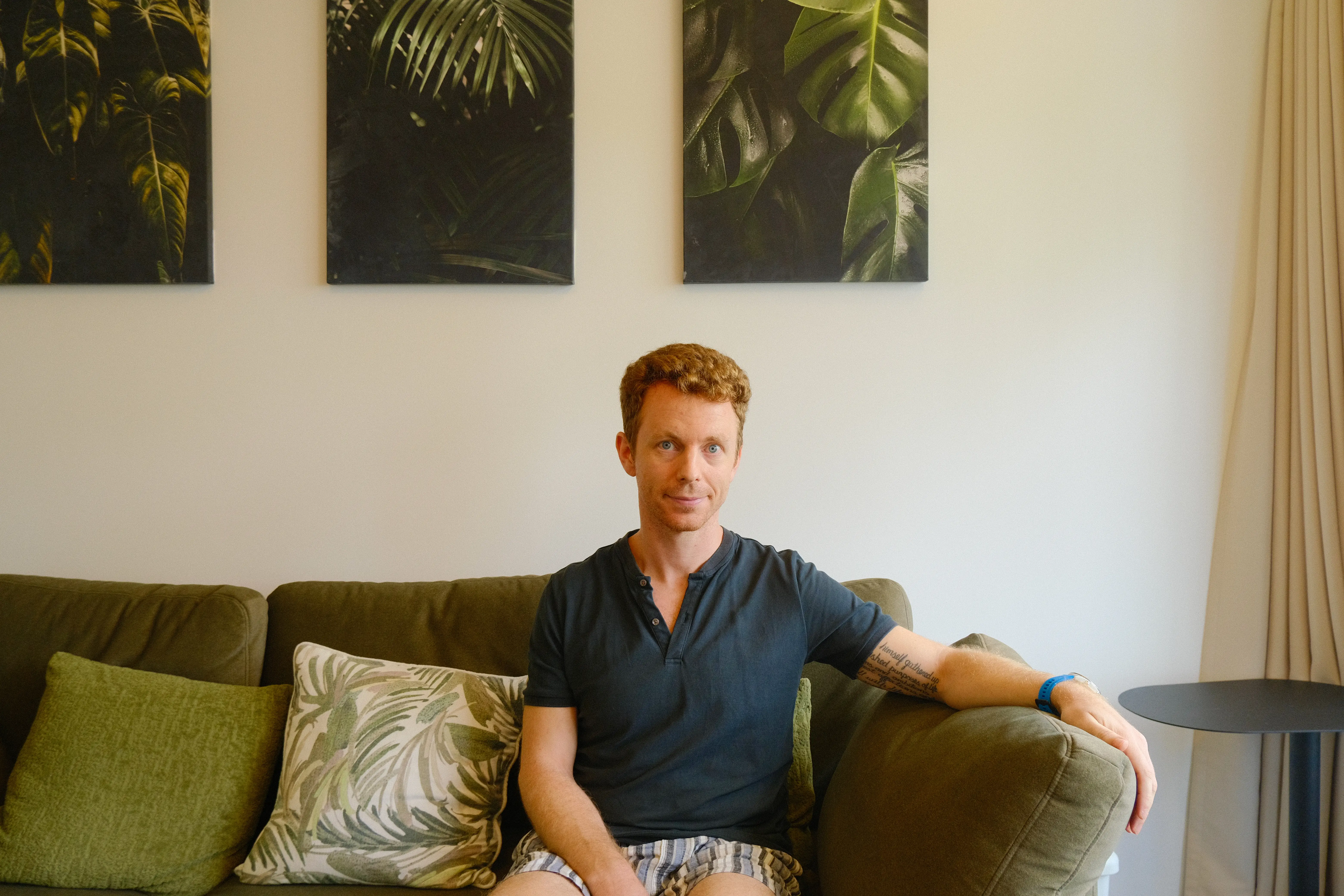 A man sitting on a green couch in Singapore.
