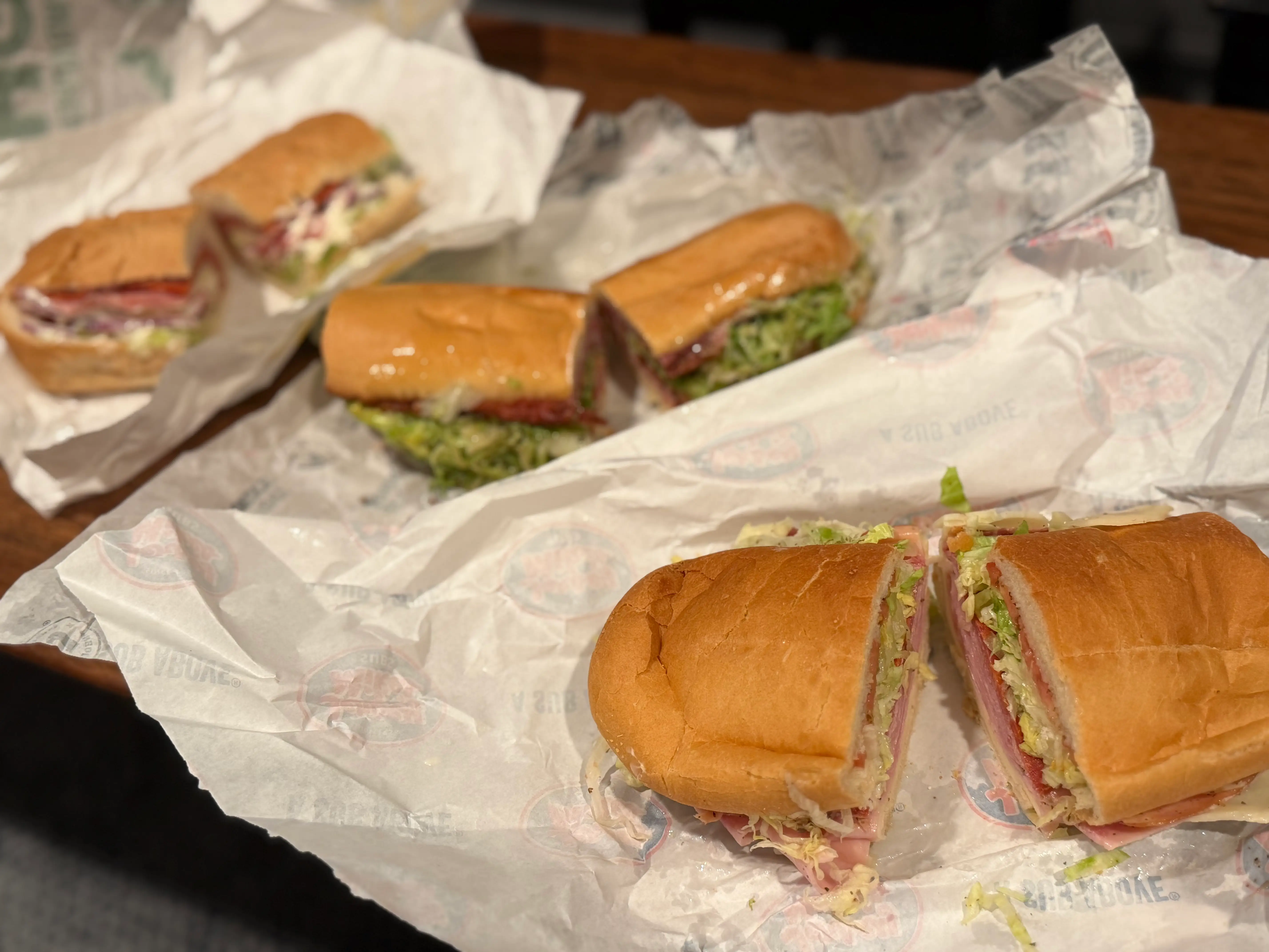 Three Italian sandwiches on papers