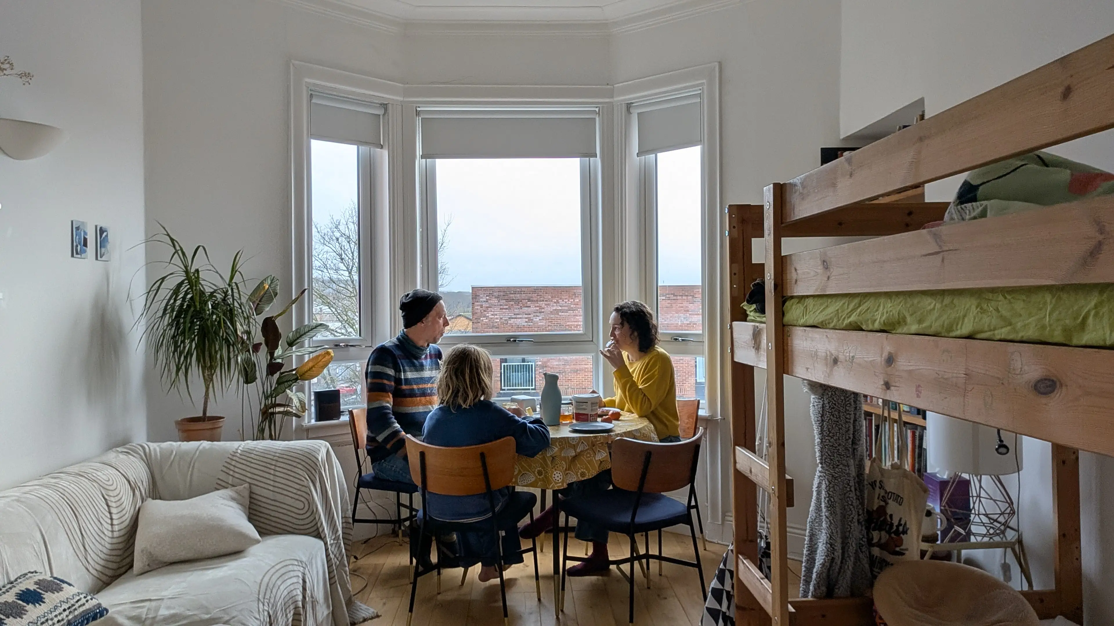 Family sitting around a table in front of windows