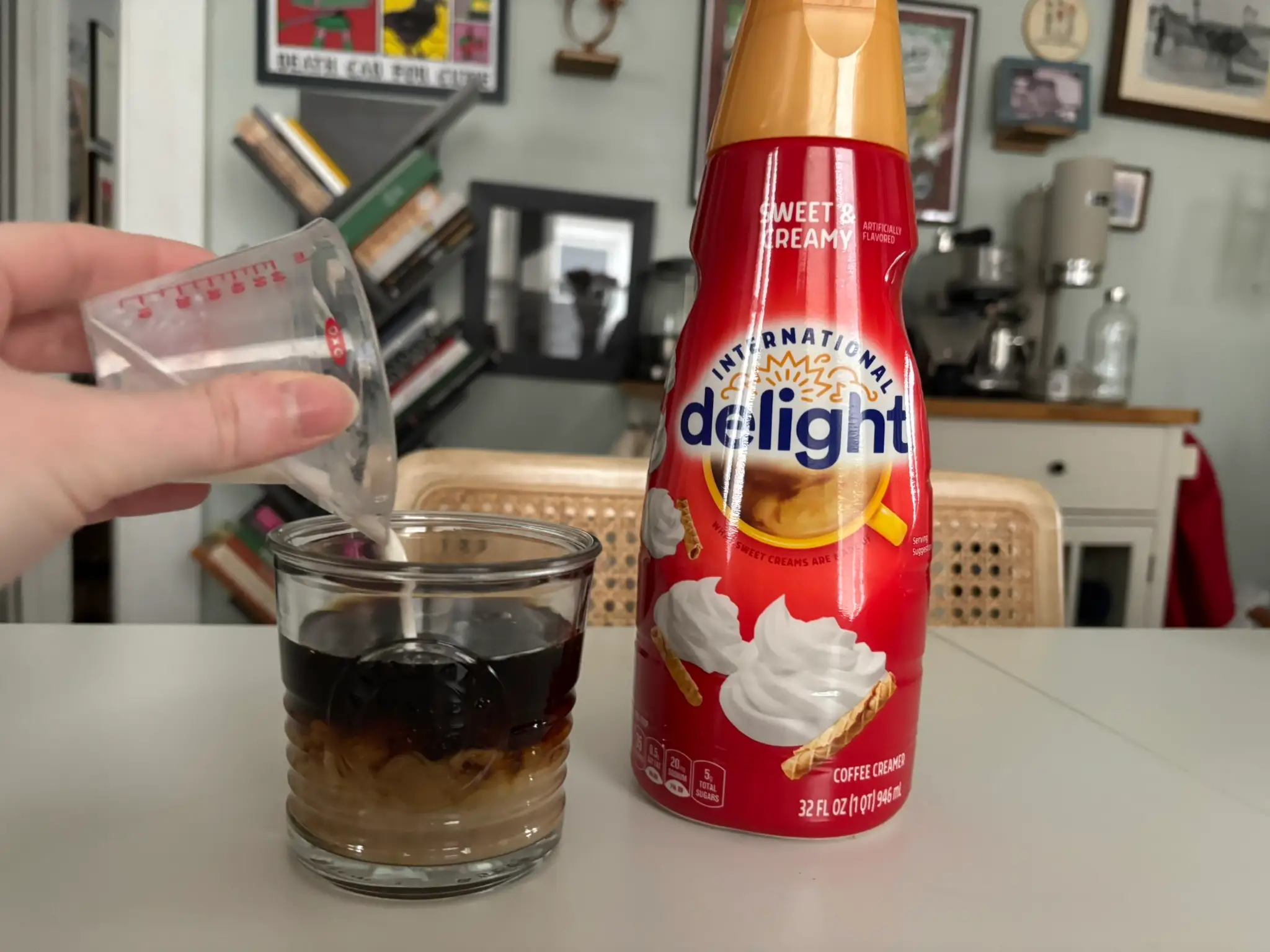 International delight sweet cream creamer with cup of coffee with cream being poured into it next to it