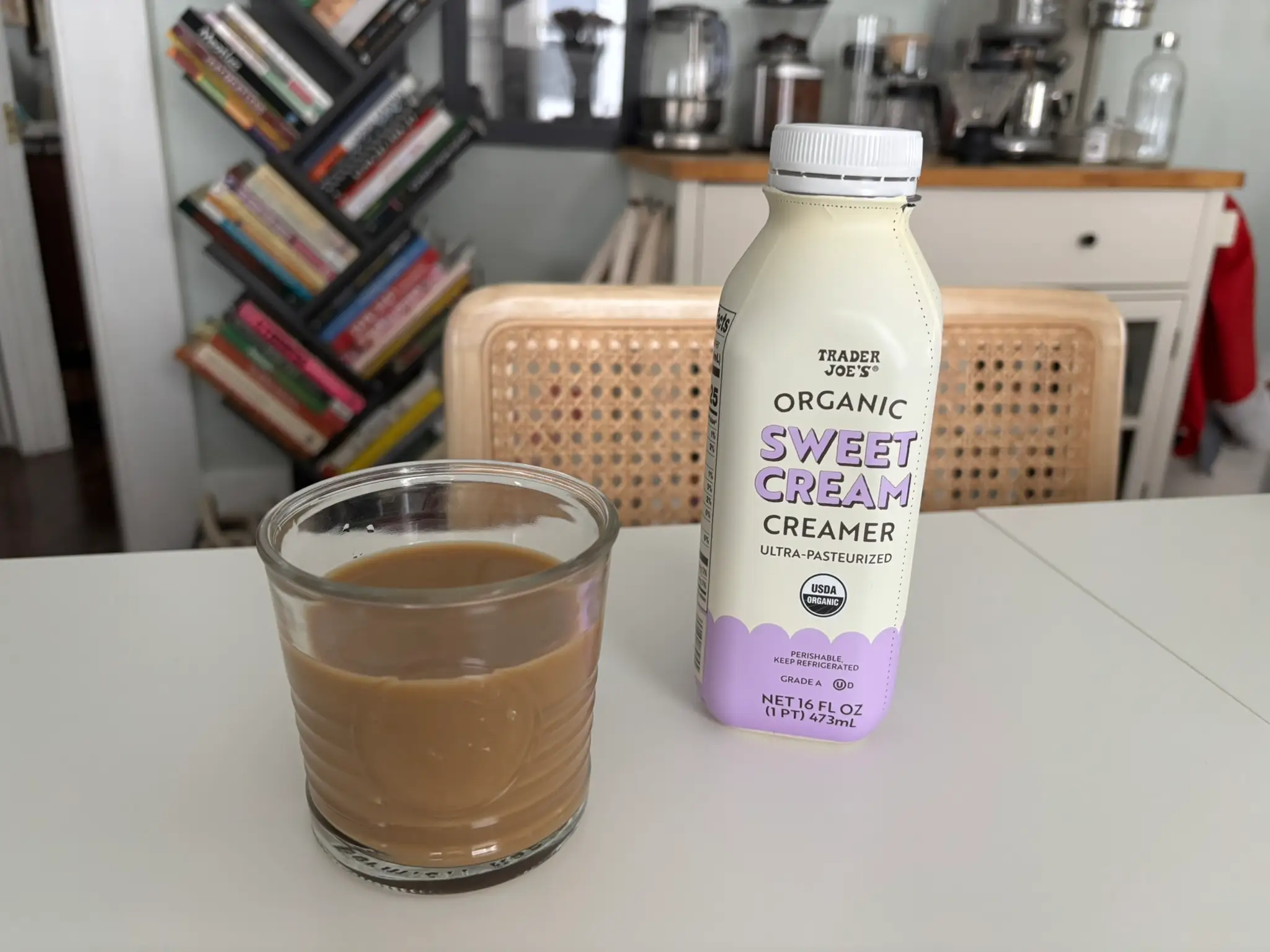 Trader Joe's sweet cream creamer next to cup of coffee with cream