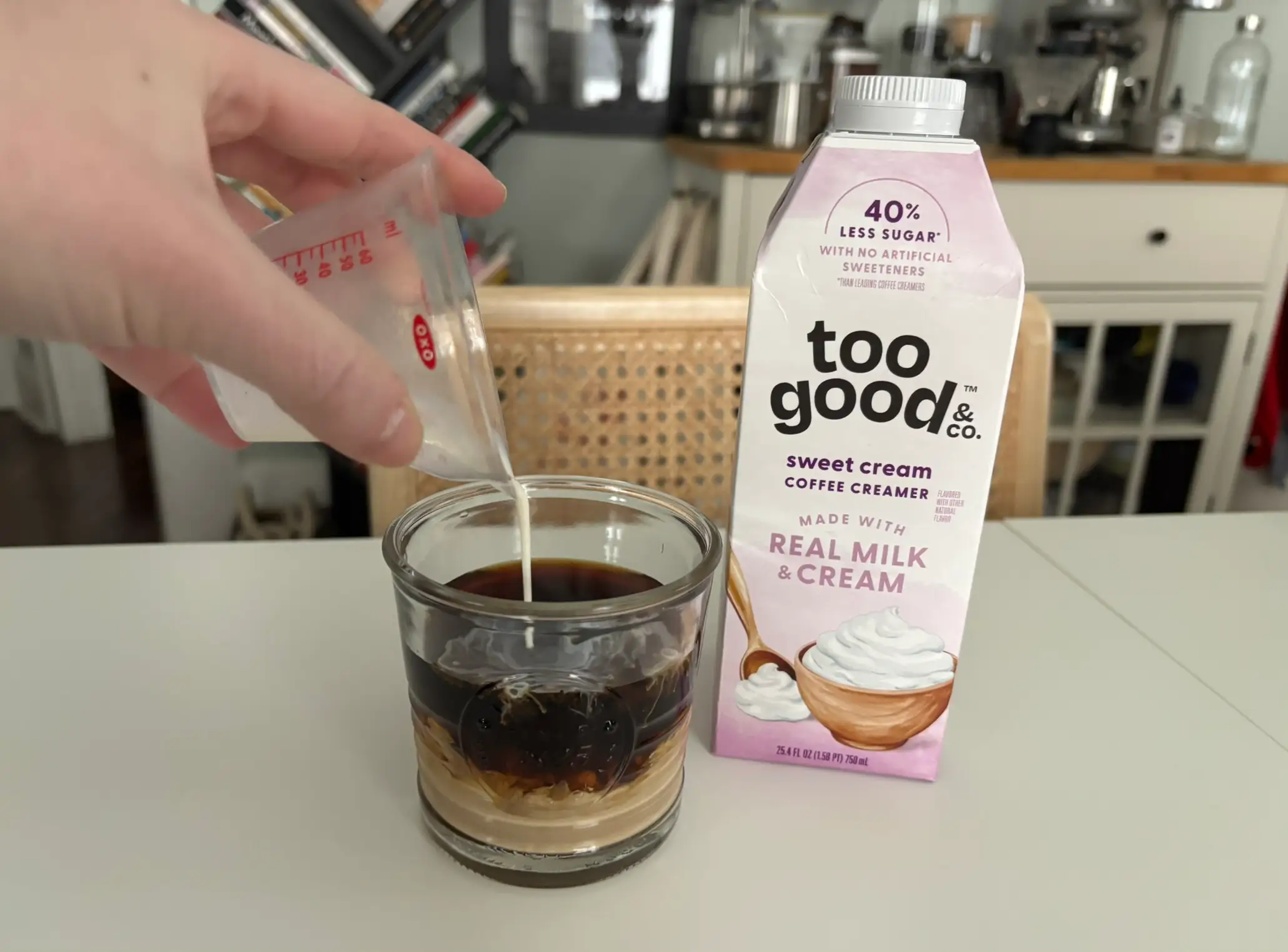 Too Good sweet cream creamer with cup of coffee with cream being poured into it next to it