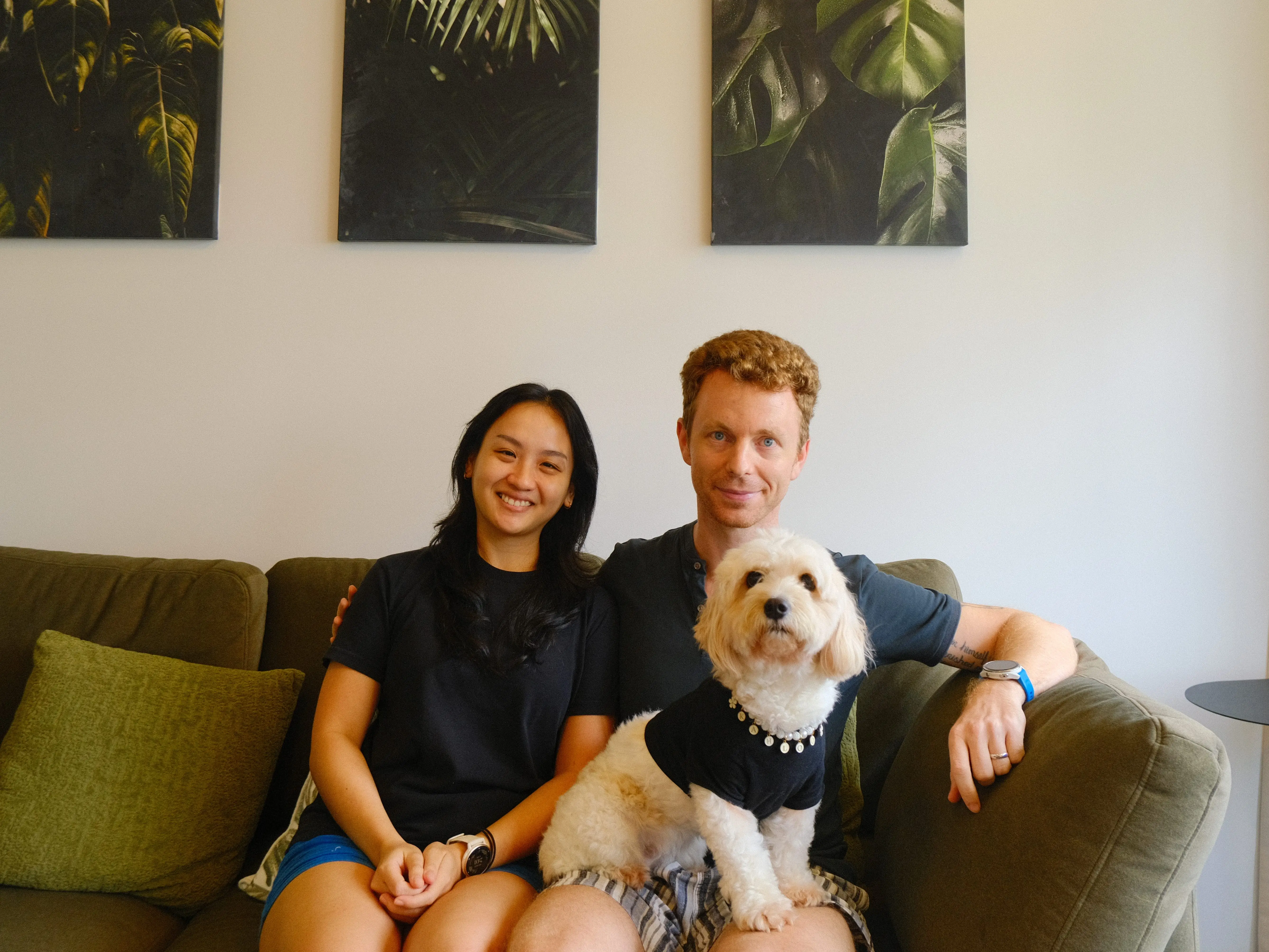 A couple posing on their couch in Singapore HDB flat with their dog.