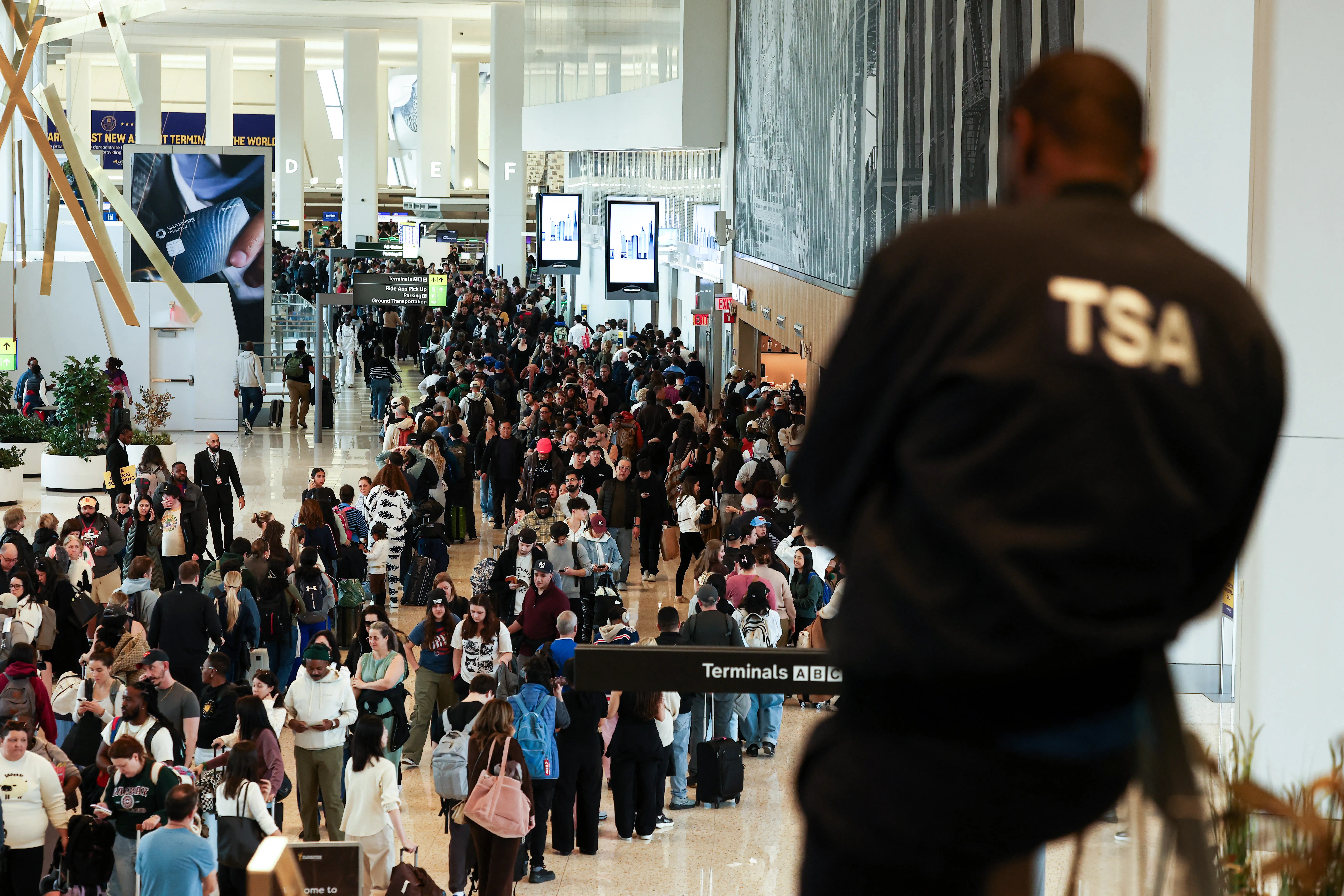 A TSA agent surveys the security line at New York LaGuardia airport.