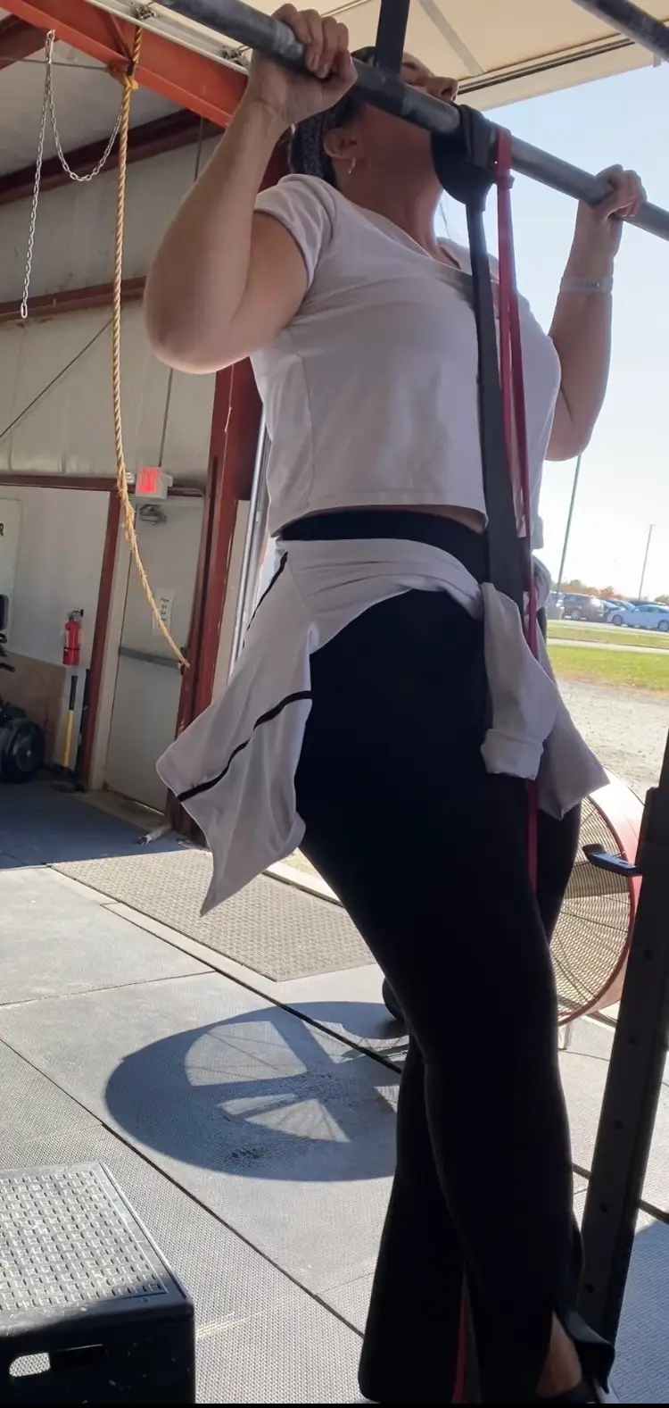 Alexandra Frost doing assisted pull-up in gym