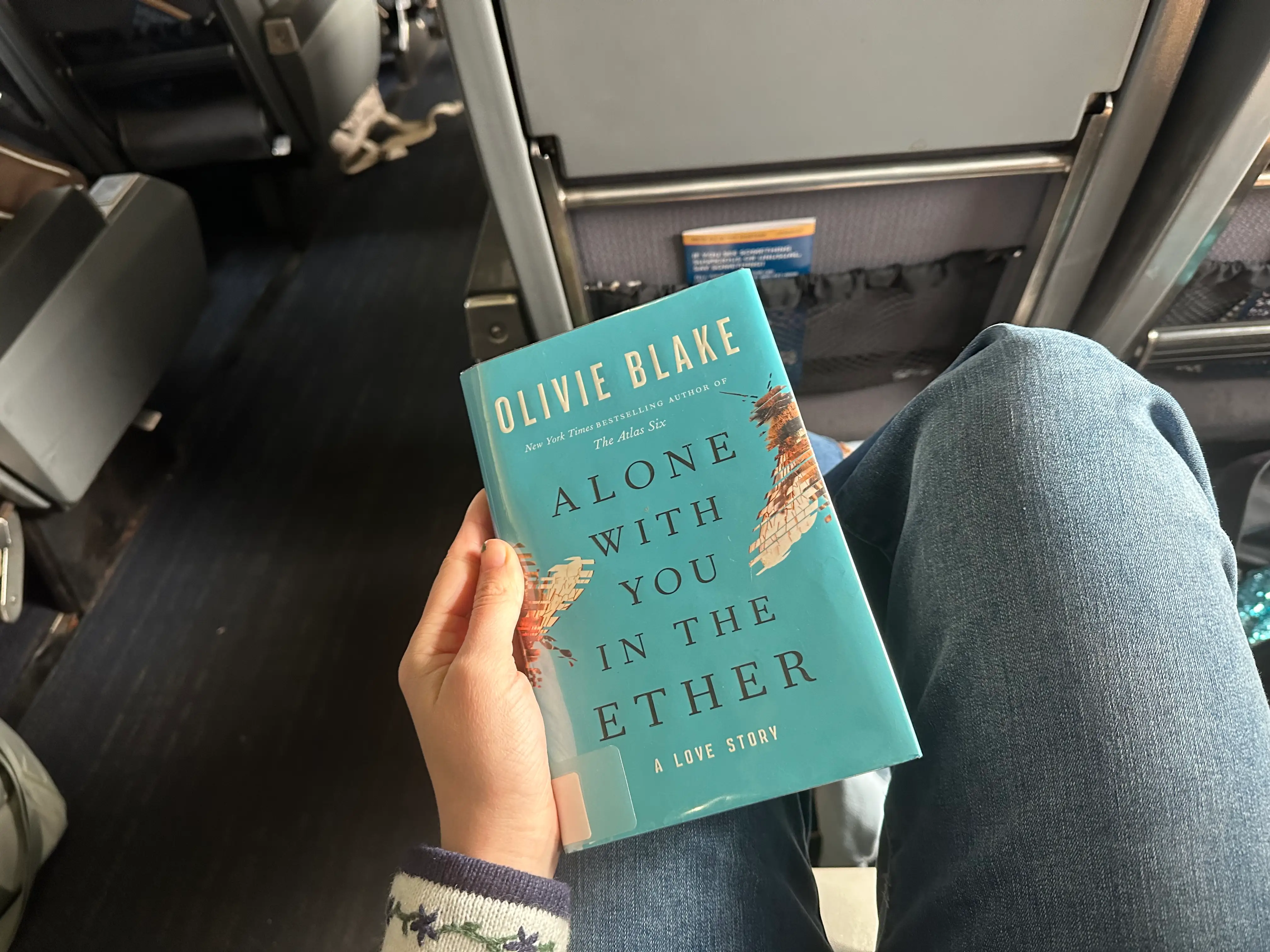 Person holding book on lap on Amtrak train