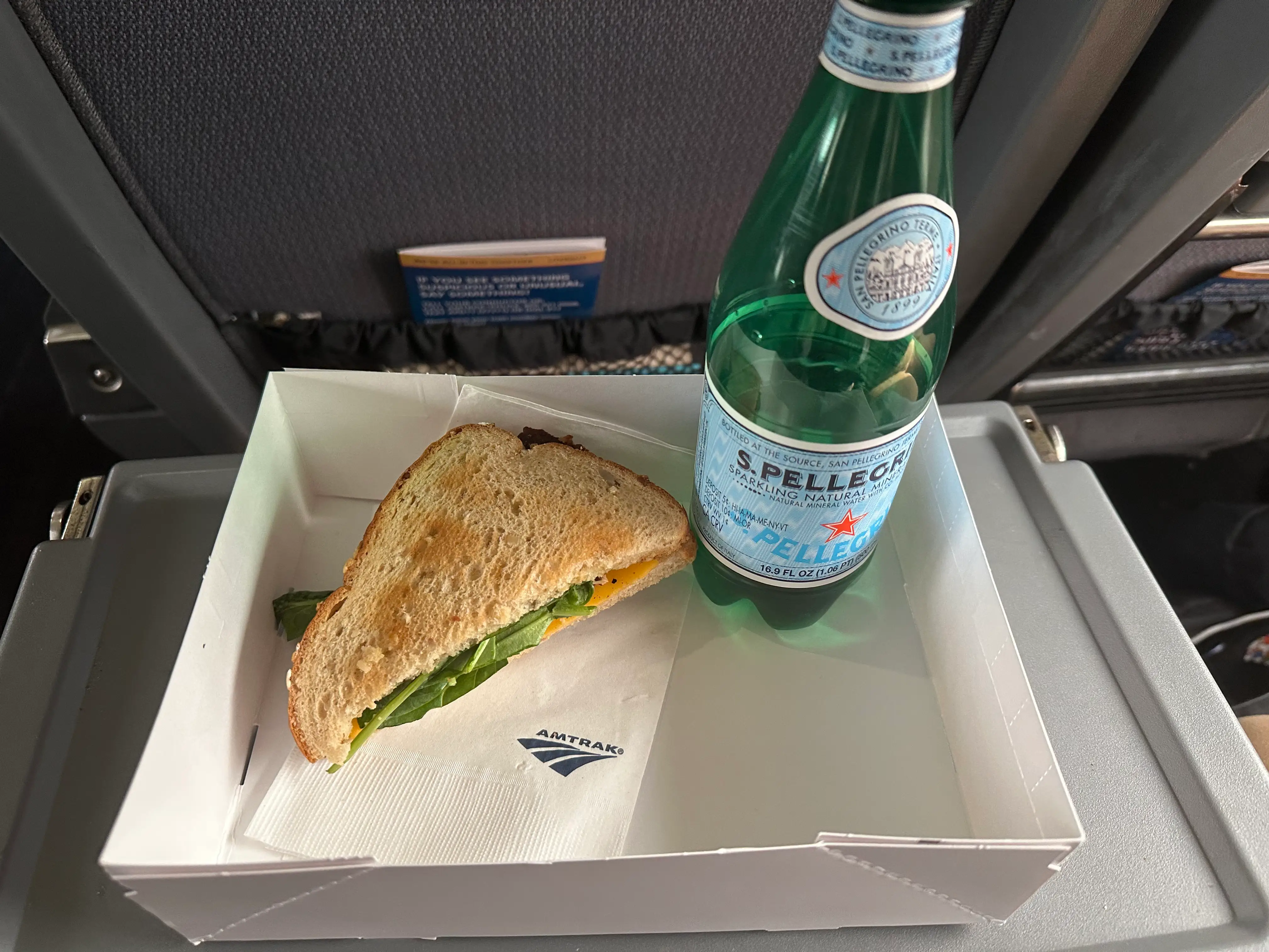 Sandwich and San Pelegrino on tray on tray table on Amtrak train