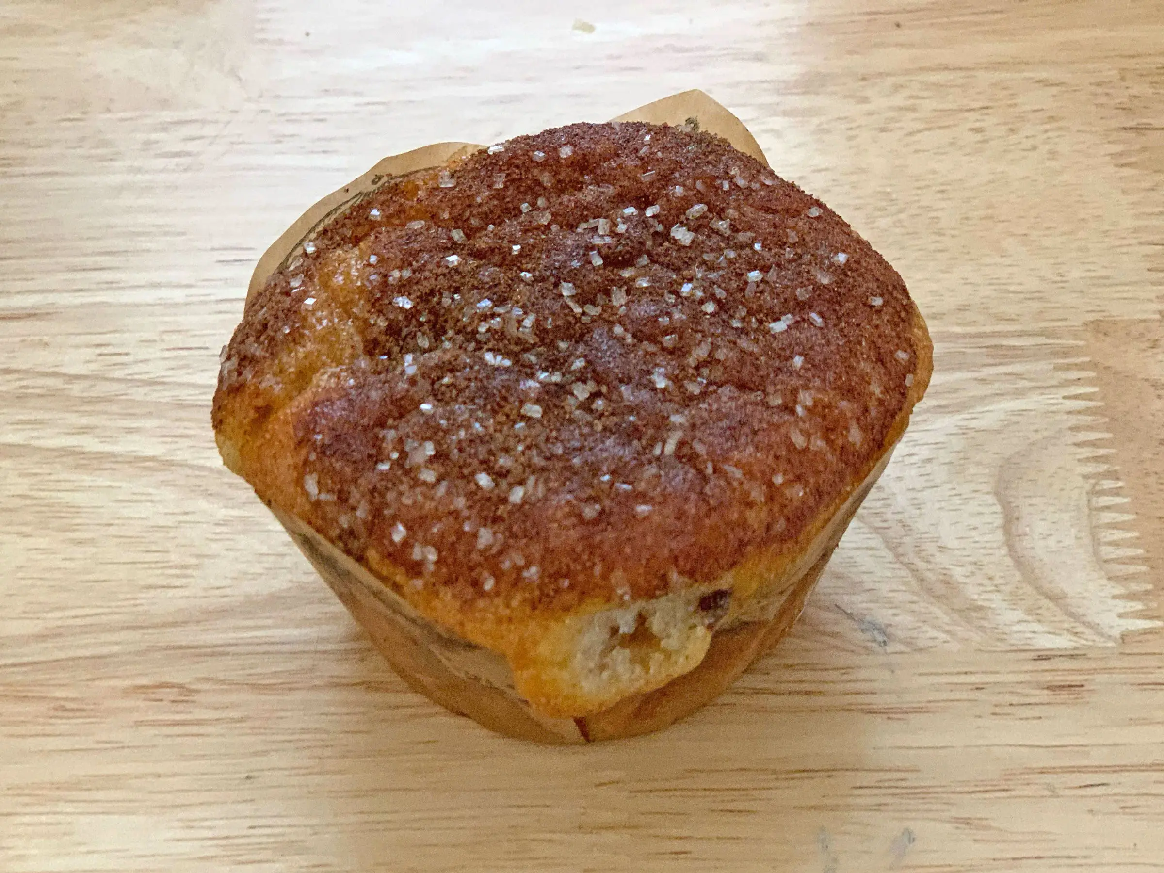 A Trader Joe's coffee cake muffin on a wooden counter.