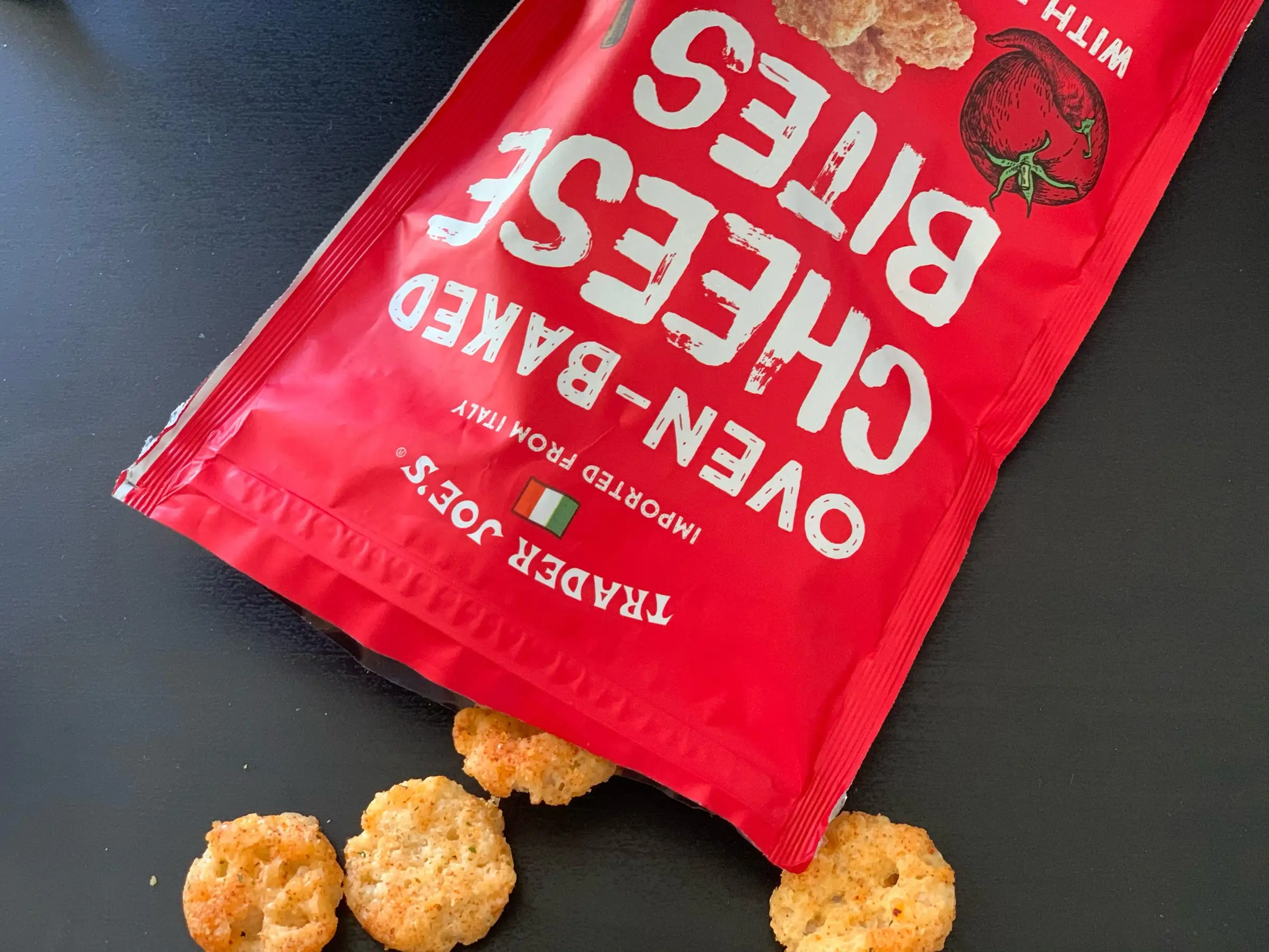 A red bag of Trader Joe's cheese bites with some spilling out.