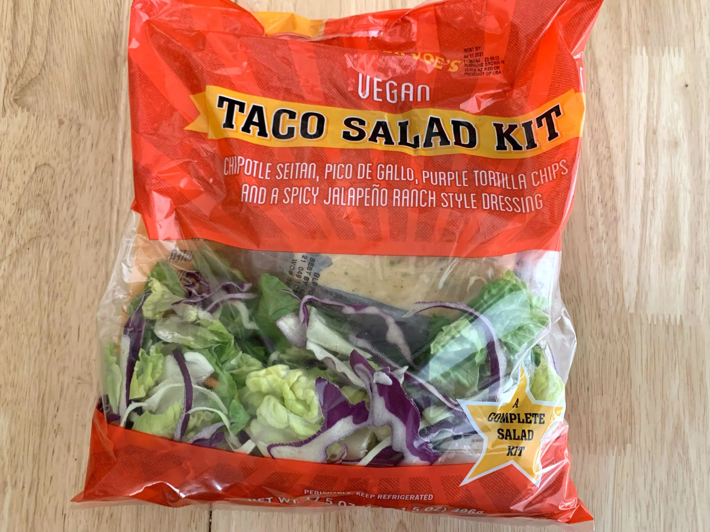 A bag of Trader Joe's vegan taco salad on a wooden counter.