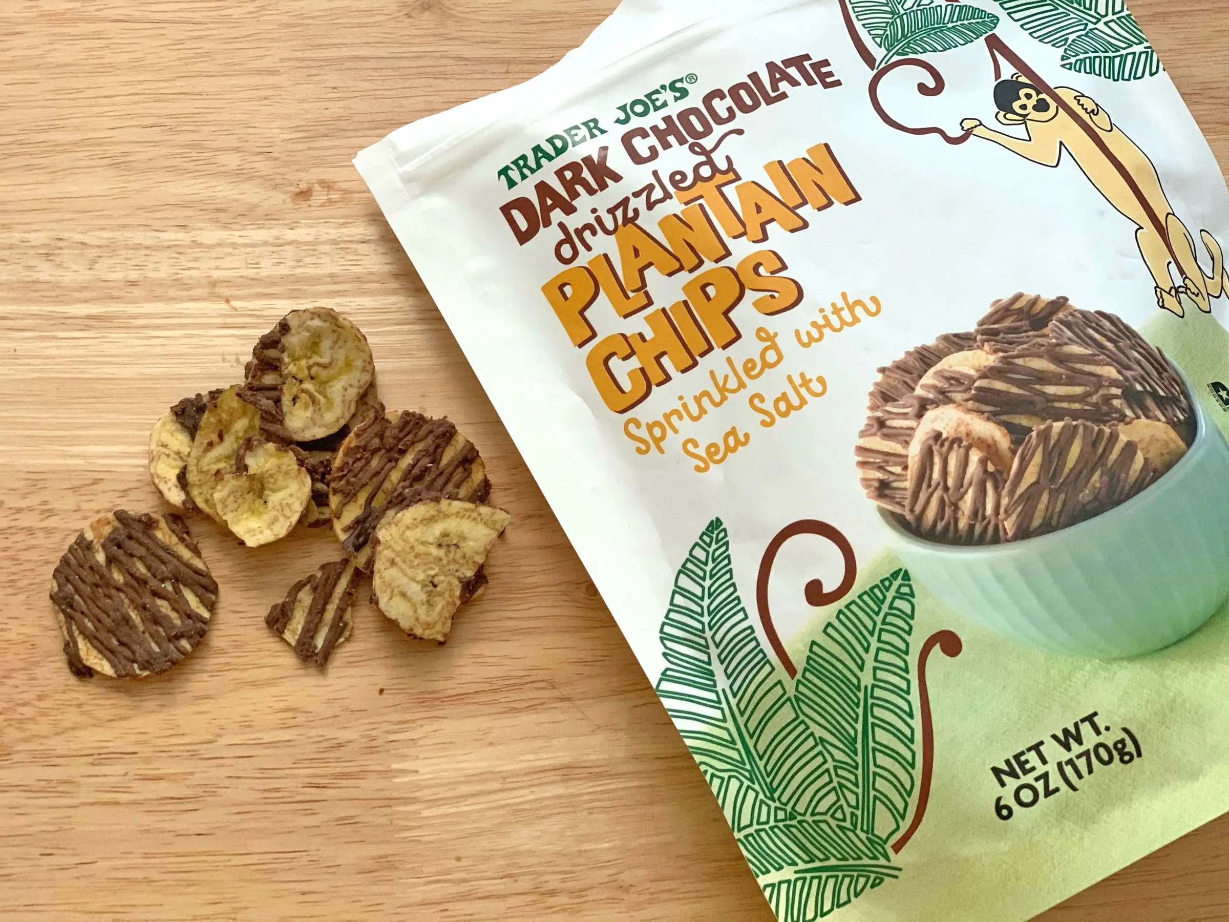 Plantain chips with a dark-chocolate drizzle on top next to the bag the product came in.
