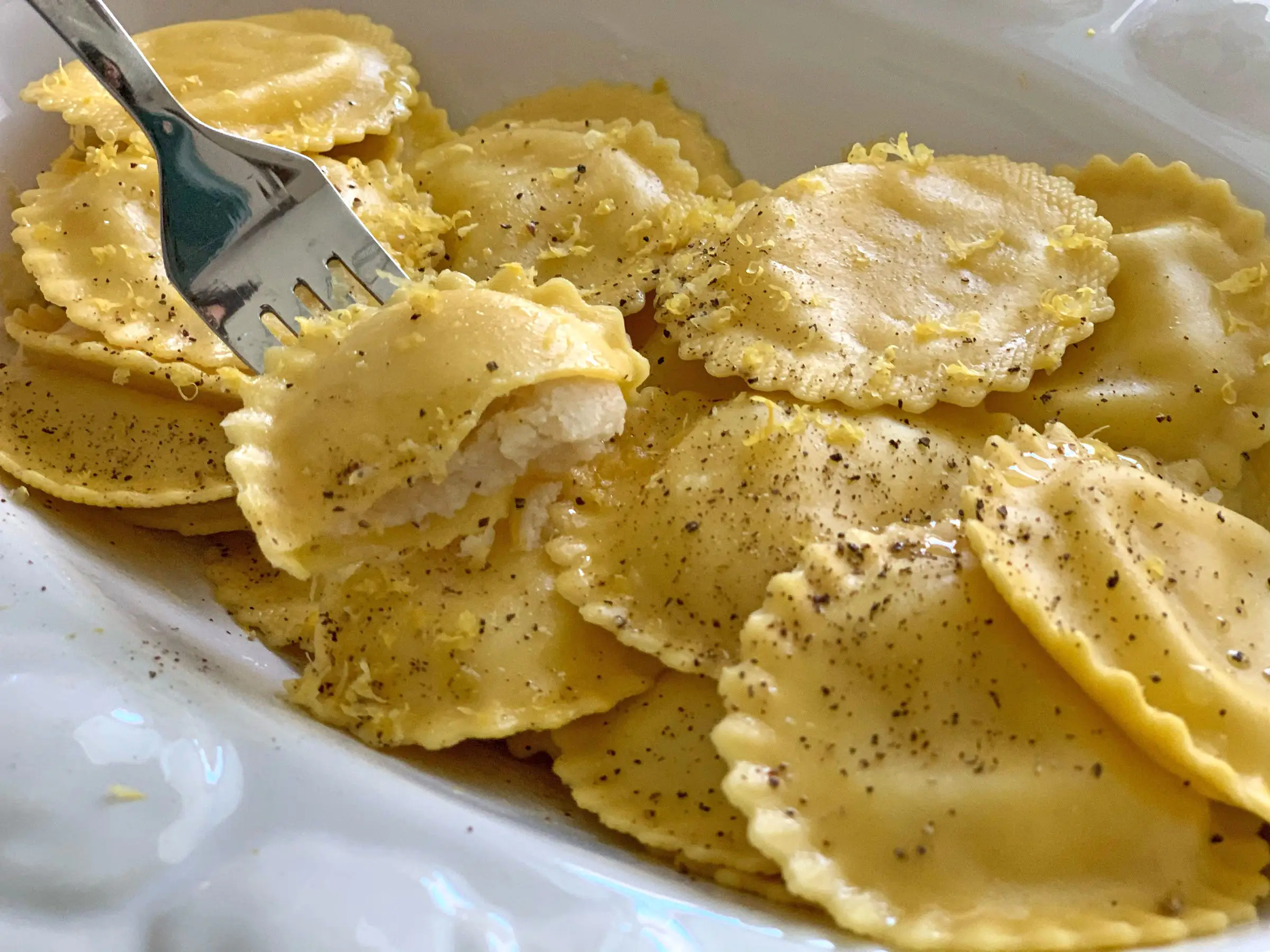 A fork scooping up a piece of ravioli.
