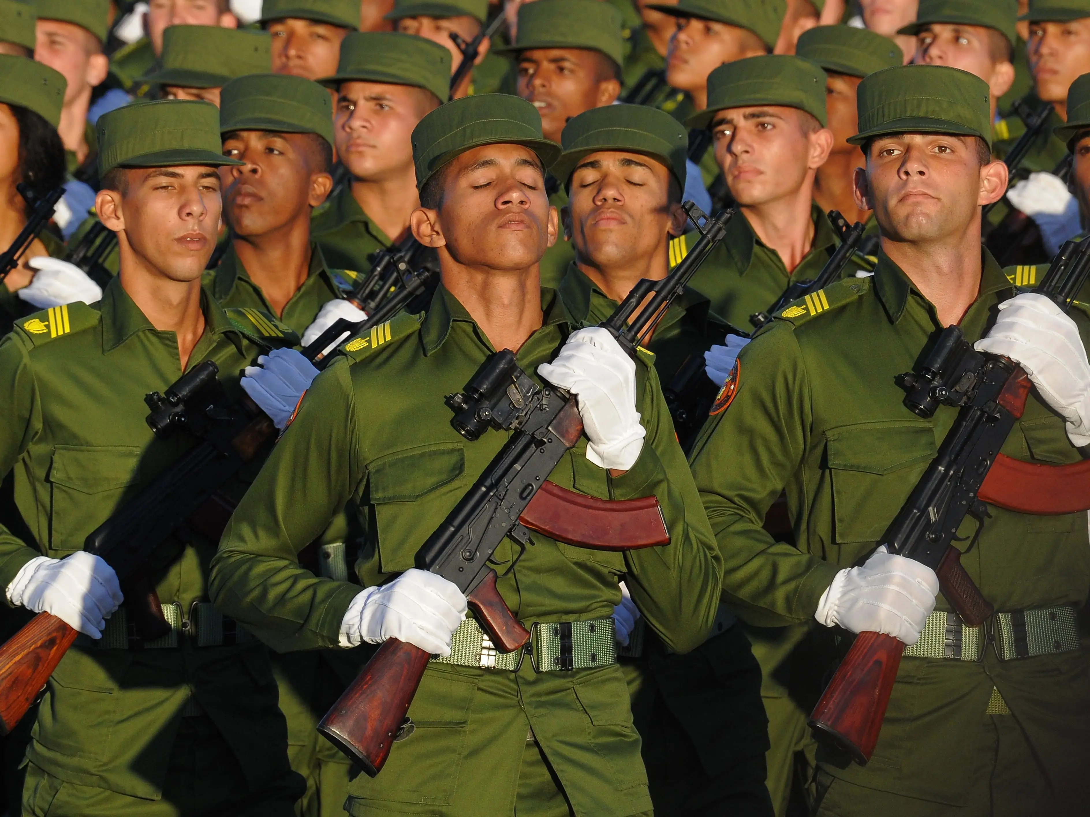 Cuban troops stand in uniform with rifles.