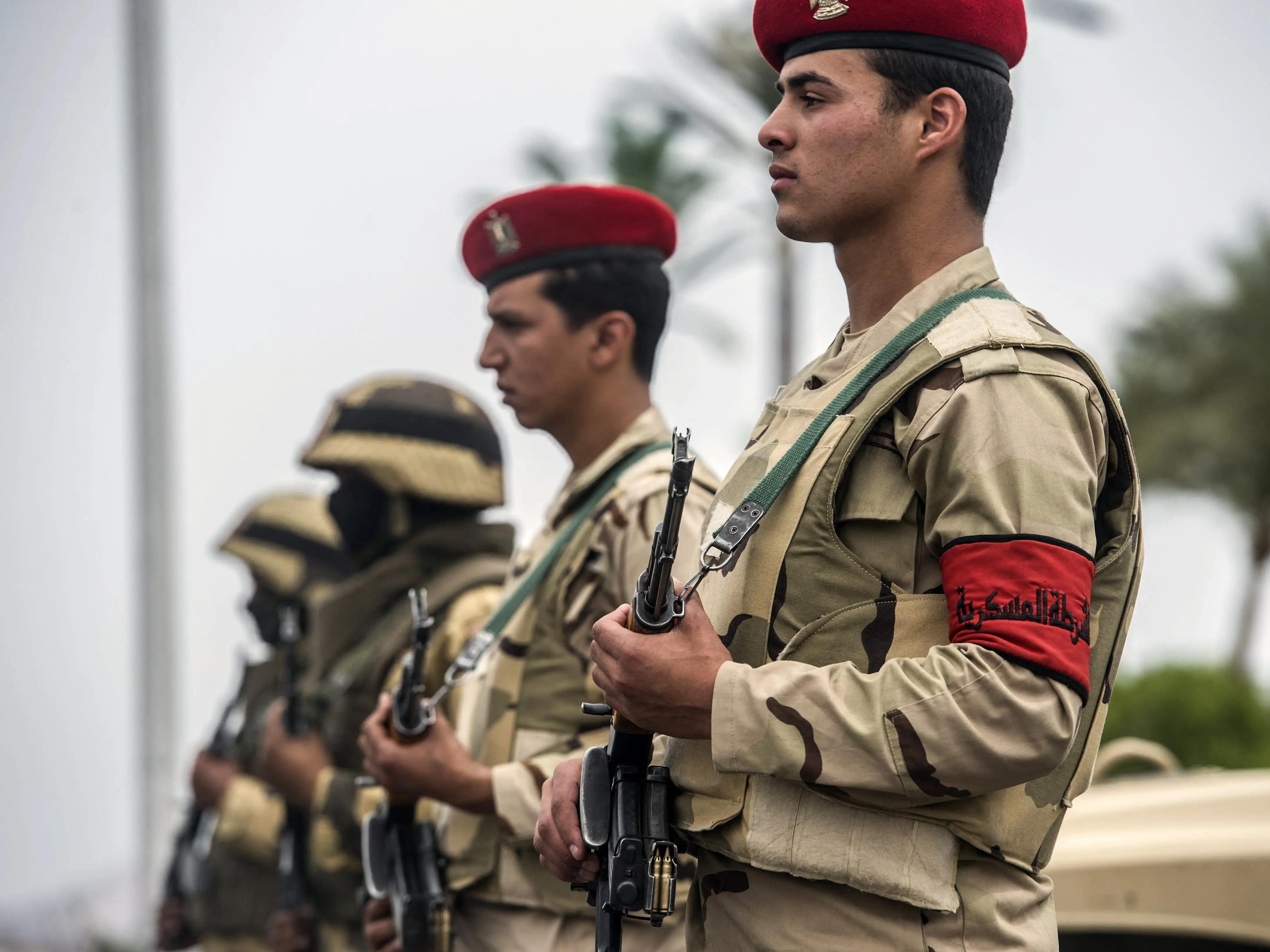 Egyptian soldiers stand in uniform with rifles.
