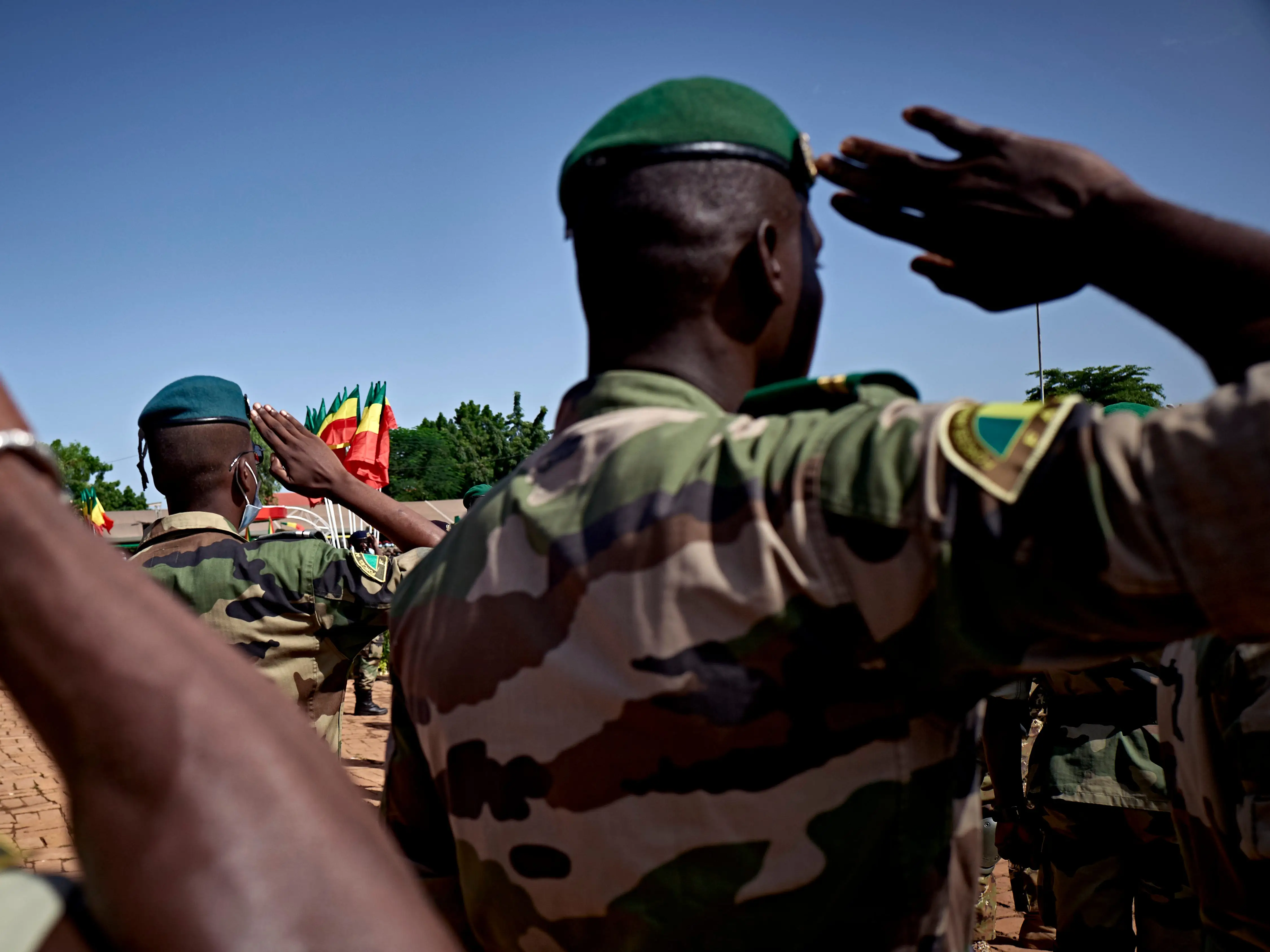 Soldiers of the Malian Armed Forces in uniform saluting.